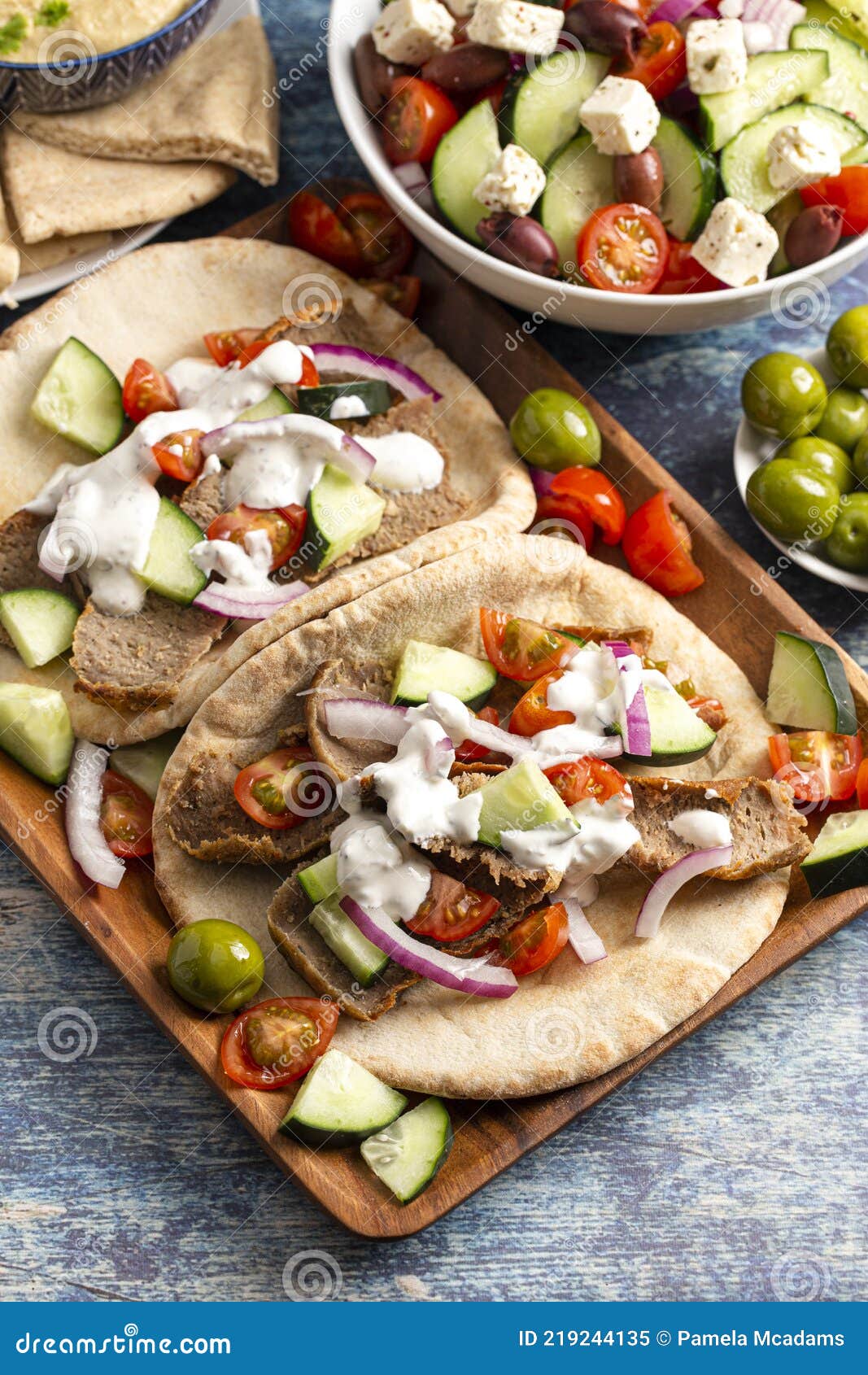 Gyros with Vegetables and White Garlic Sauce on a Rustic Wooden Table
