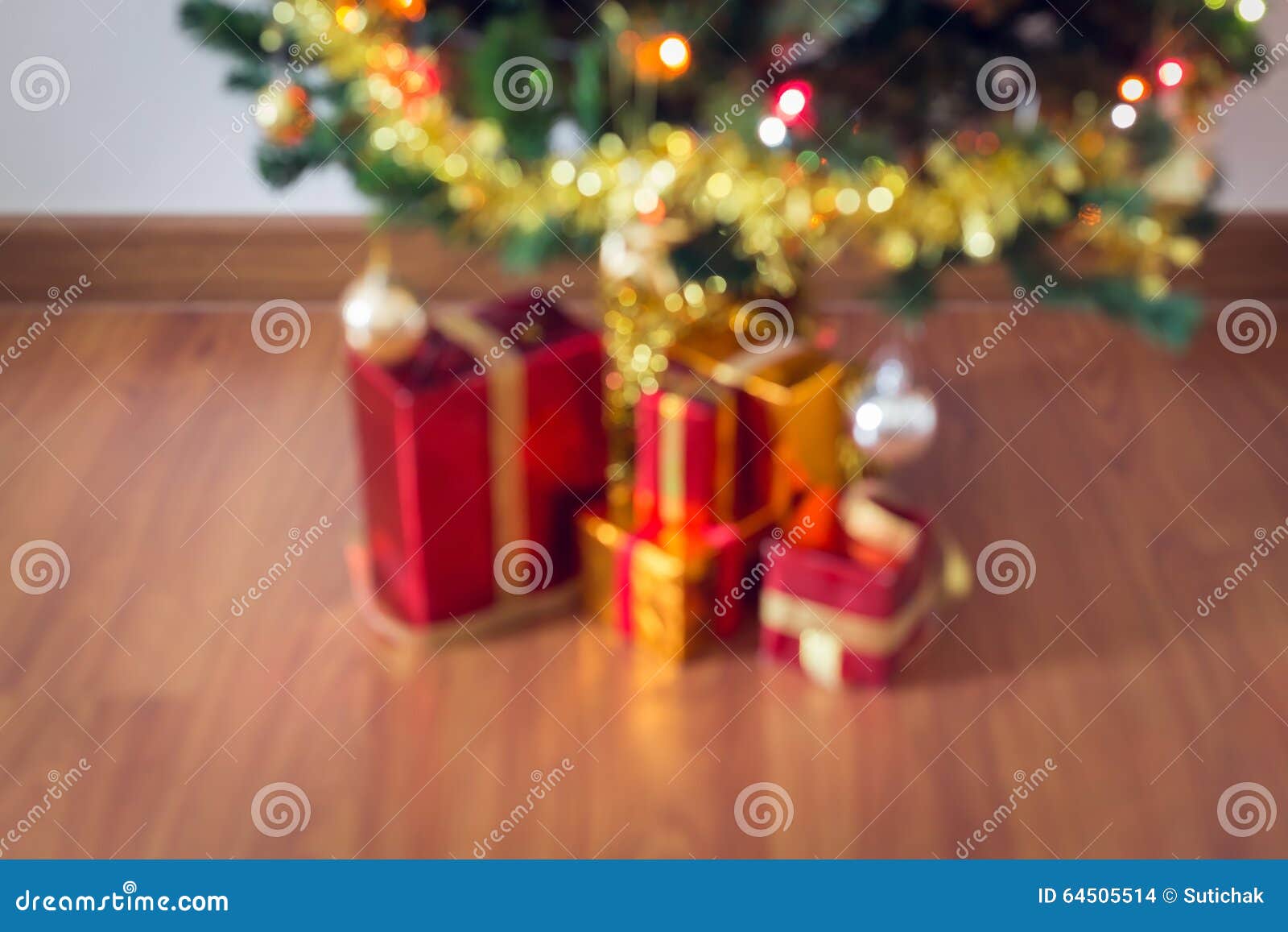 Gör suddig ljus beröm på julträd med gåvaasken i vardagsrum