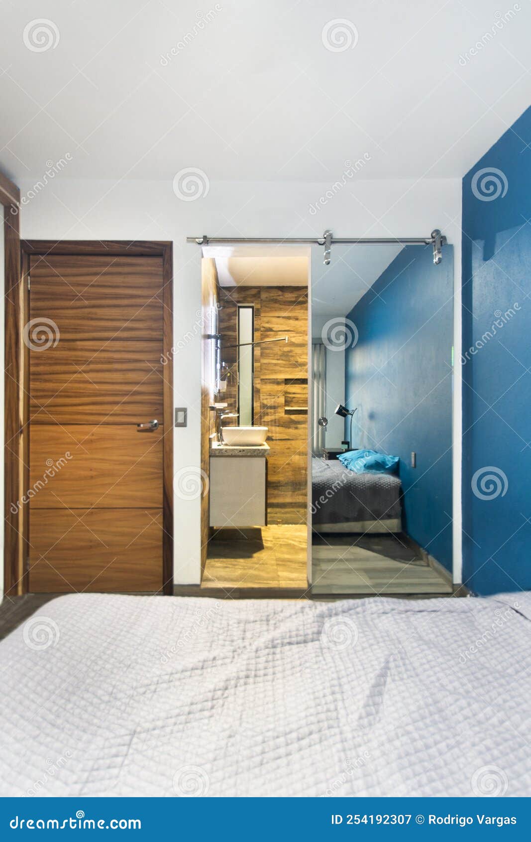 Habitación Al Fondo, Se Ve Un Cuarto De Baño Con Puerta Corredera De  Espejos Y Puerta De Madera Imagen de archivo - Imagen de azul, cristal:  254192307