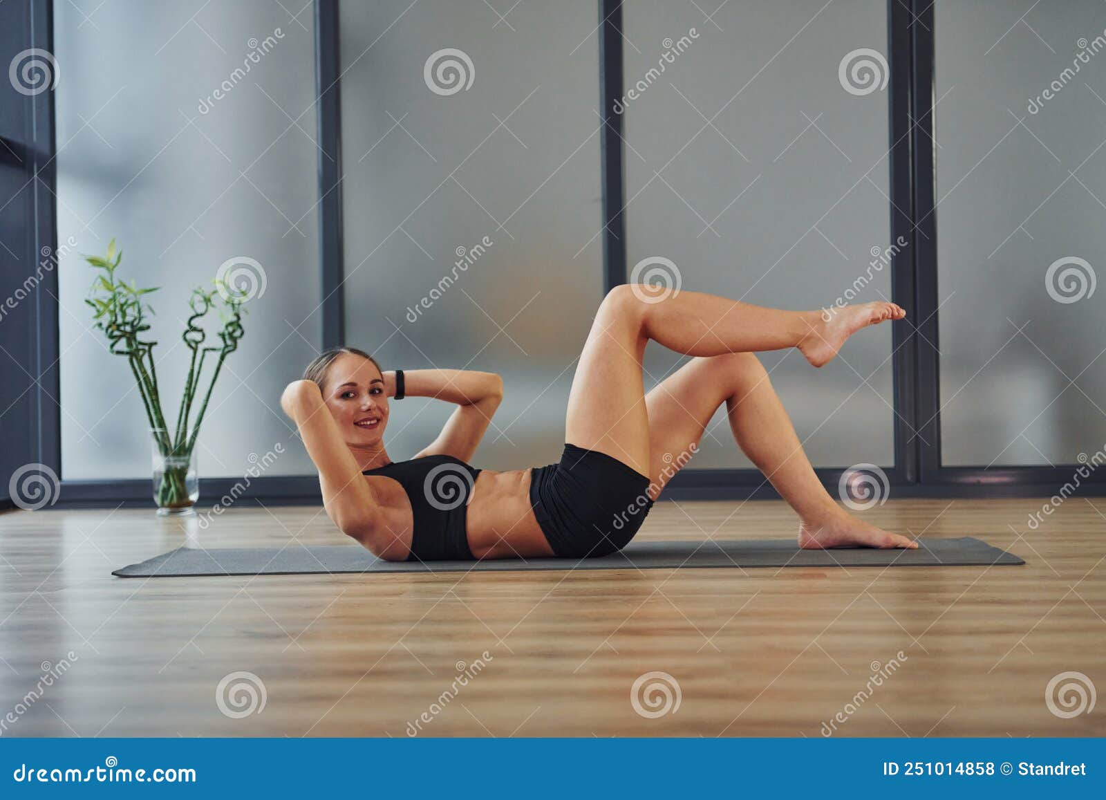 Hermosa mujer en ropa deportiva haciendo yoga en el interior