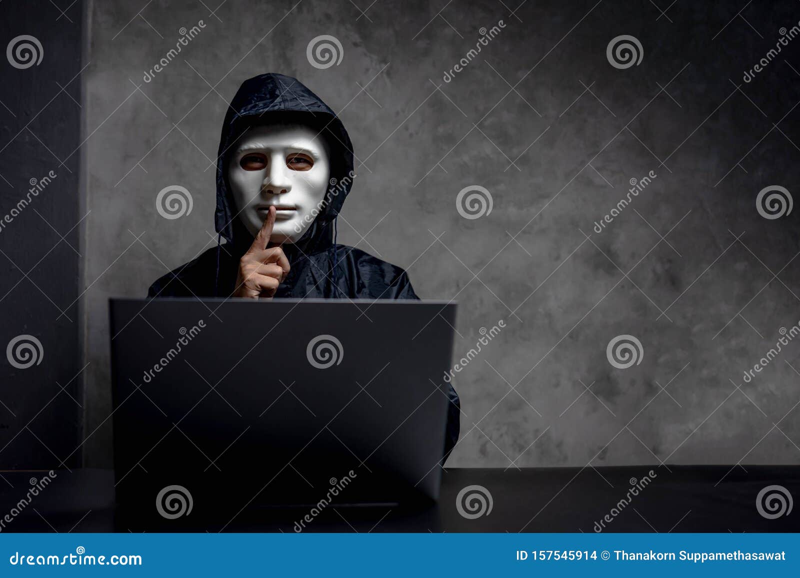 hacker wearing a white mask in front of his computer. hacker hacks network, space for text