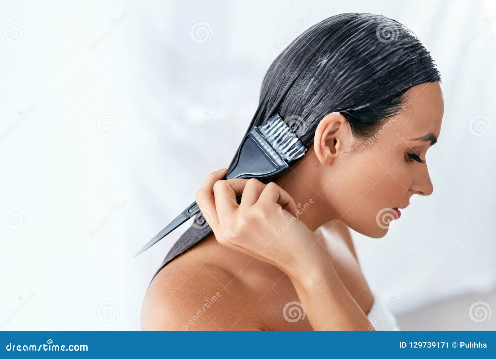 hair mask. woman applying conditioner on long hair with brush, hair care treatment