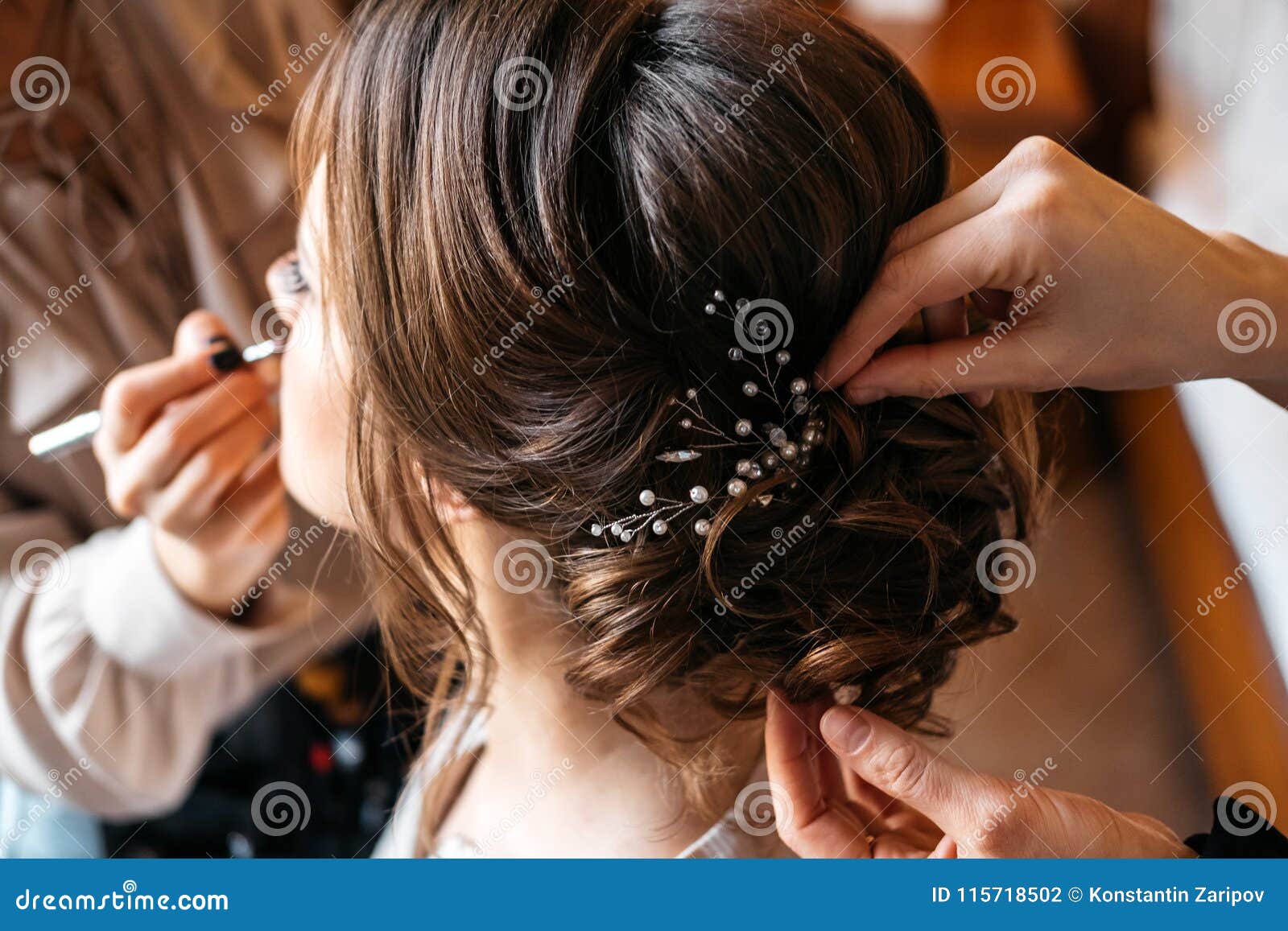 a hair stylist and make-up artist prepare a bride for the wedding day