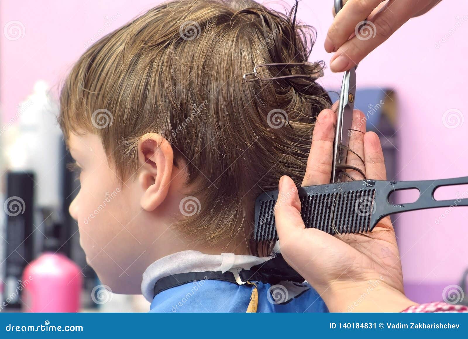 cutting a boy's hair with scissors