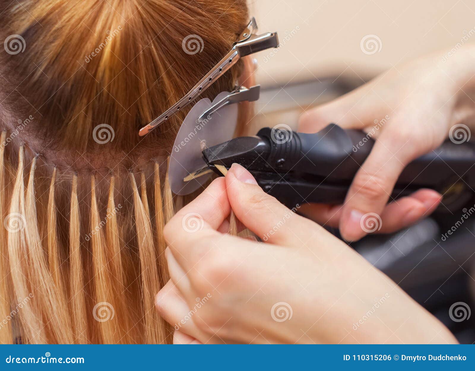 the hairdresser does hair extensions to a young girl, a blonde in a beauty salon.