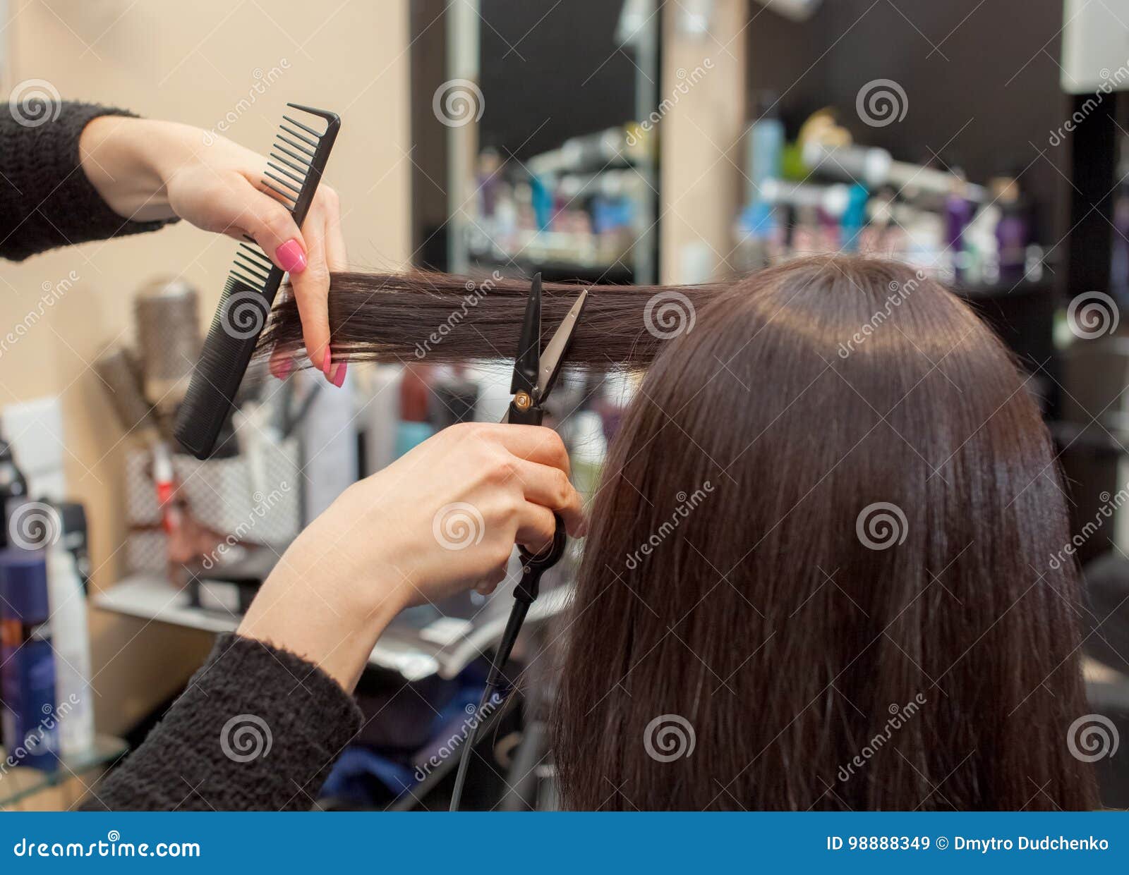 The Hairdresser Does A Haircut With Hot Scissors Of Hair To A