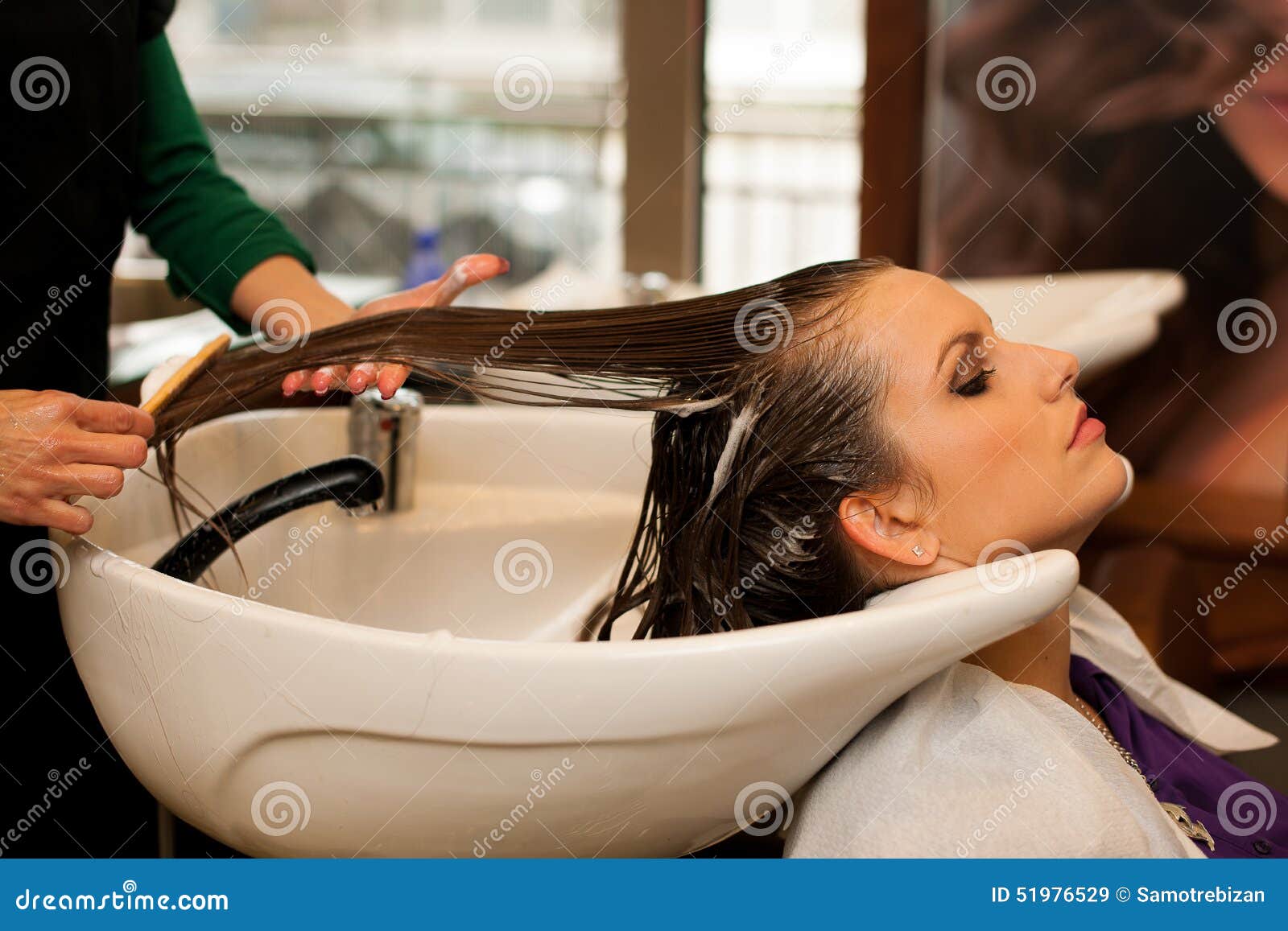 Hairdresser making hair treatment to a customer in hair salon