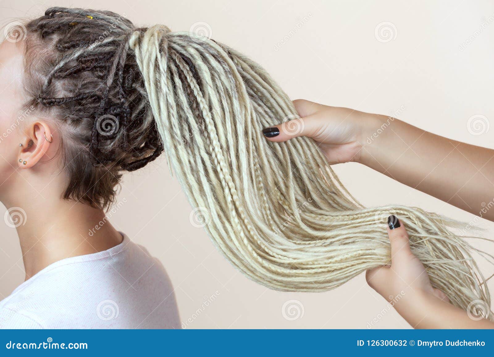 A Hairdresser Weaves Dreadlocks To A Beautiful Young Girl