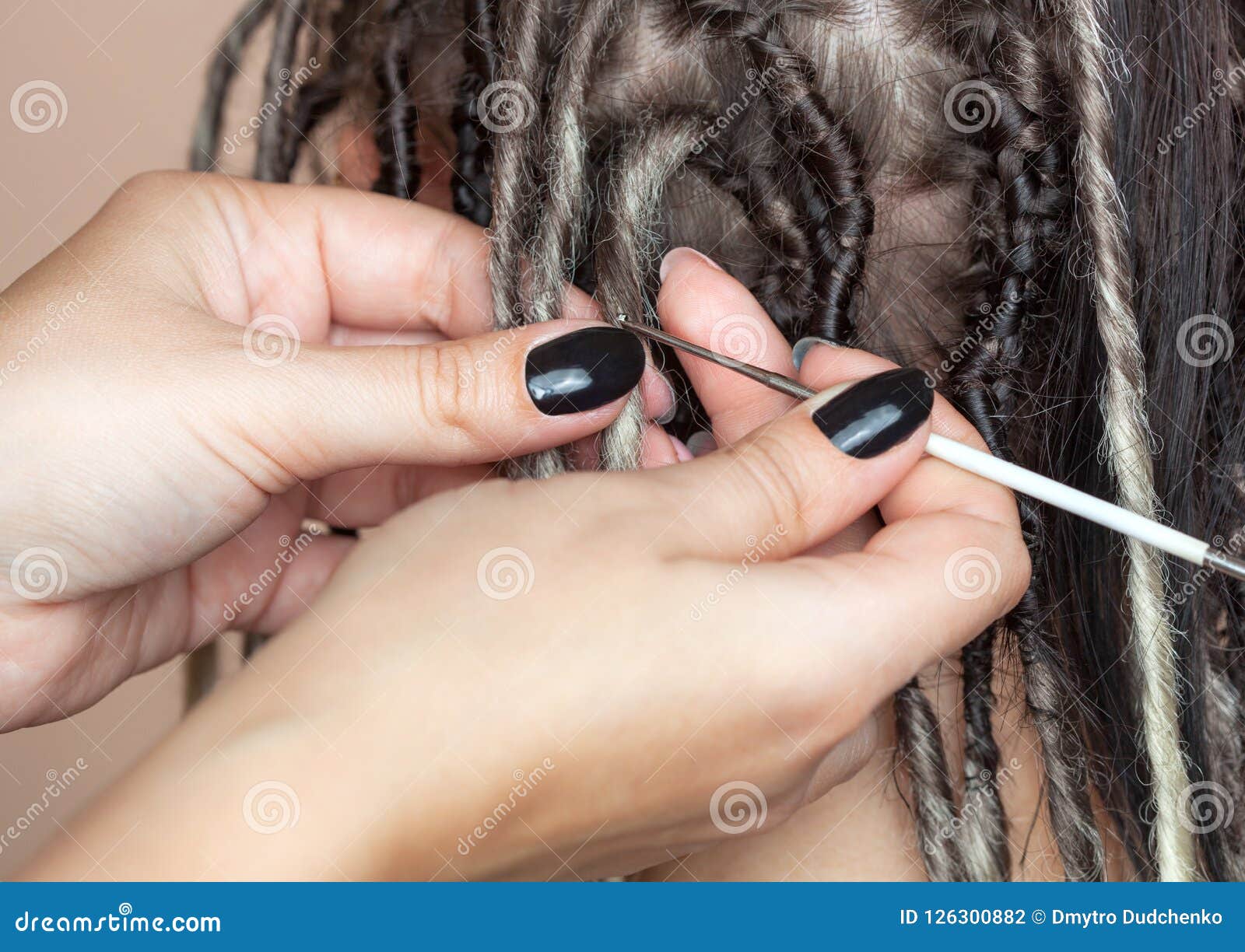 A Hairdresser Weaves Dreadlocks To A Beautiful Young Girl