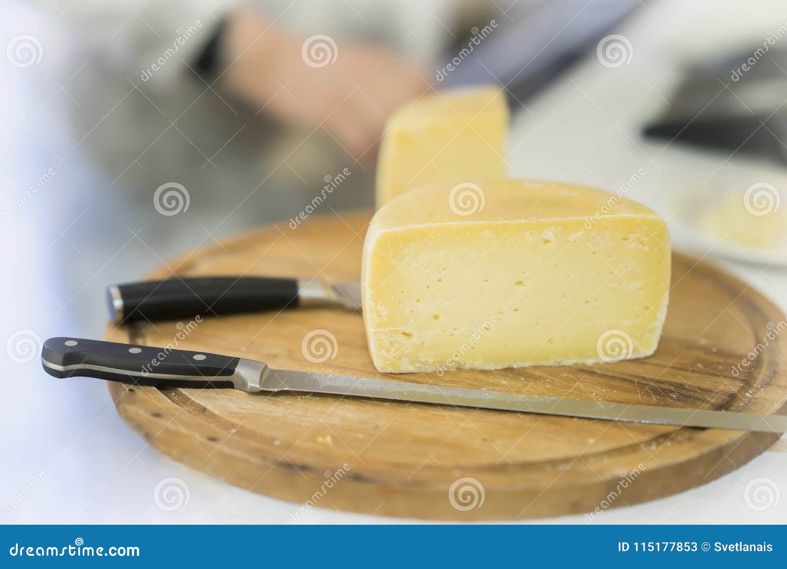 half cheese head on on wooden market board. gastronomic dairy produce, real scene in the food market