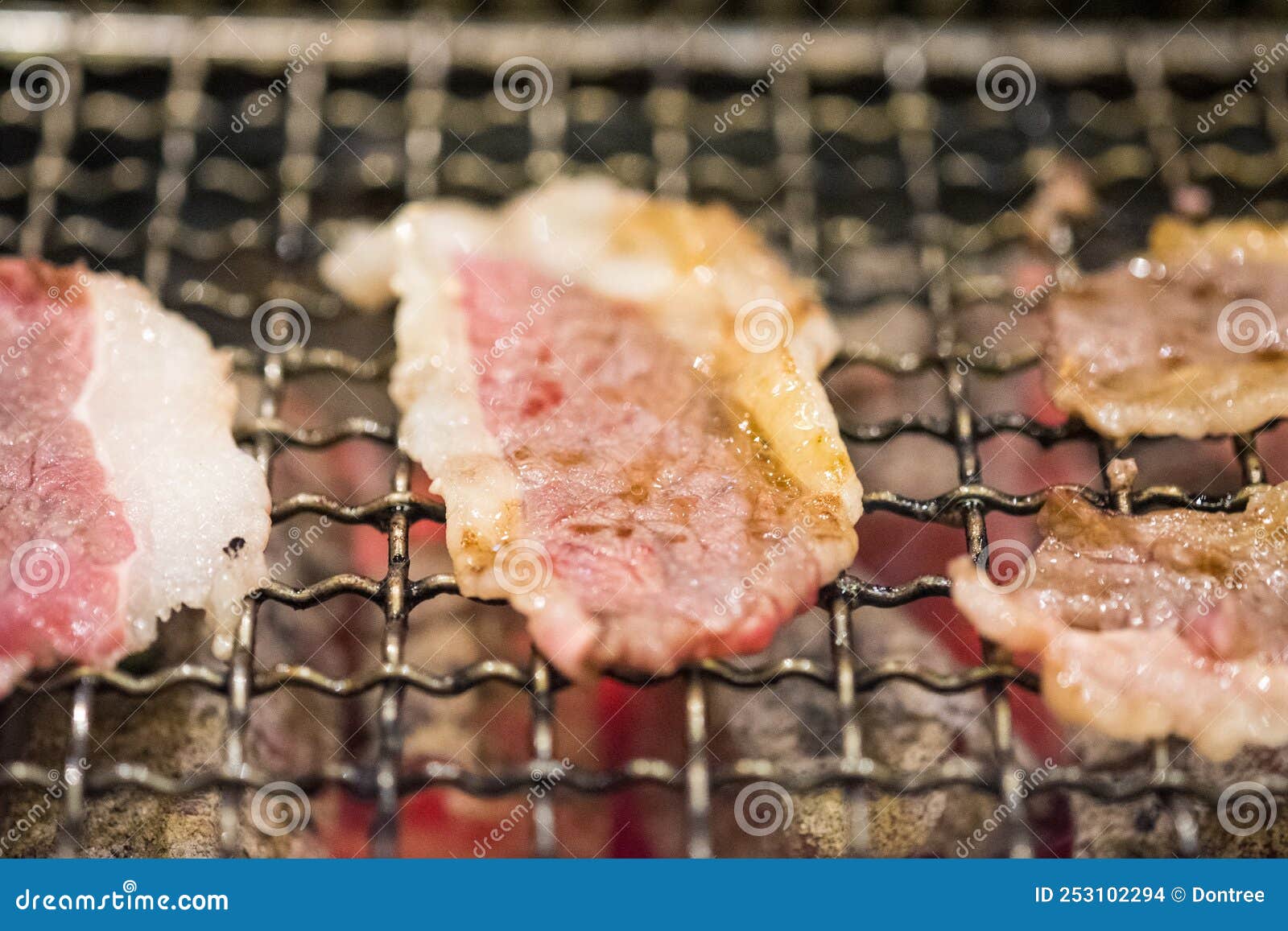 Halfcooked Sliced Beef on the Grill Stove. Yakiniku Buffet Stock Photo