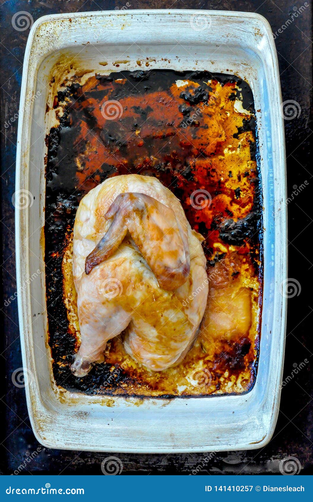 Half Roasted Chicken in a White Rectangular Roasting Pan Stock Image
