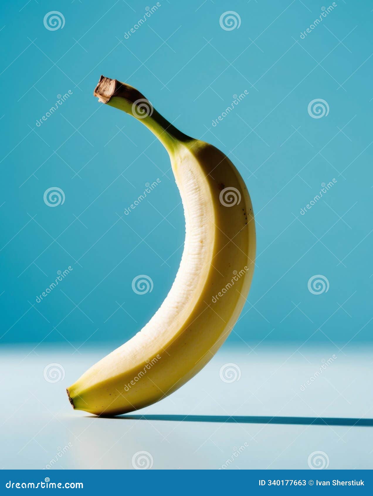 half peeled banana close up on a blue background.