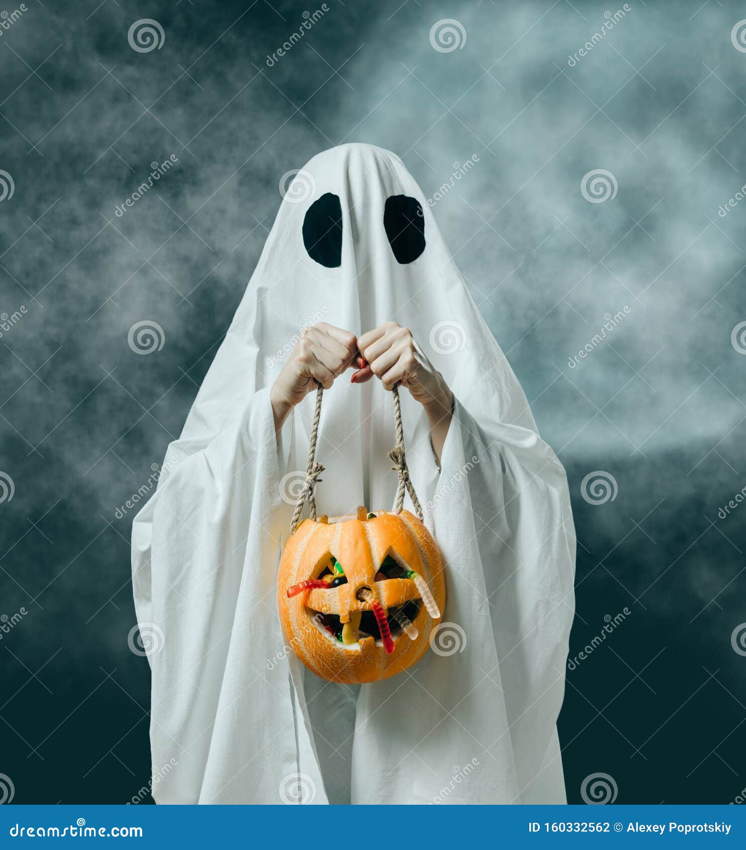 Scary ghost with halloween candy bucket and glowing Jack o lantern