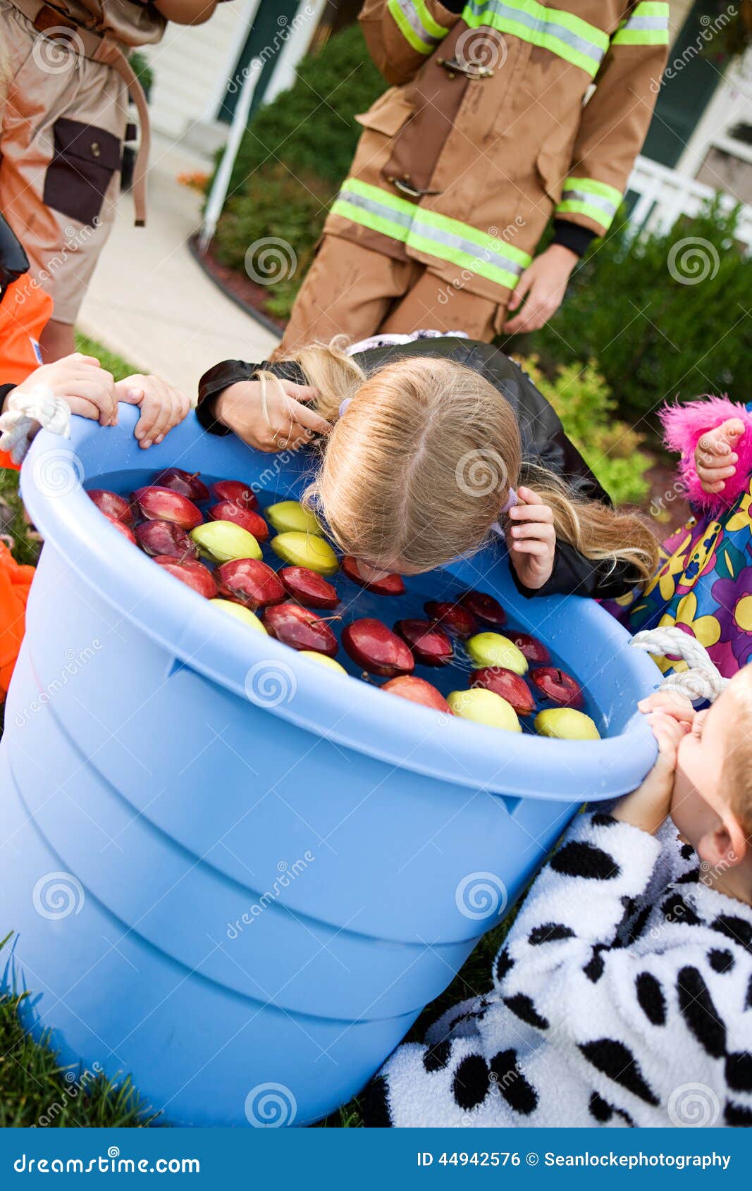 halloween-girl-bobbing-apples-group-neighborhood-children-having-fun-costume-trick-treating-playing-games-44942576.jpg