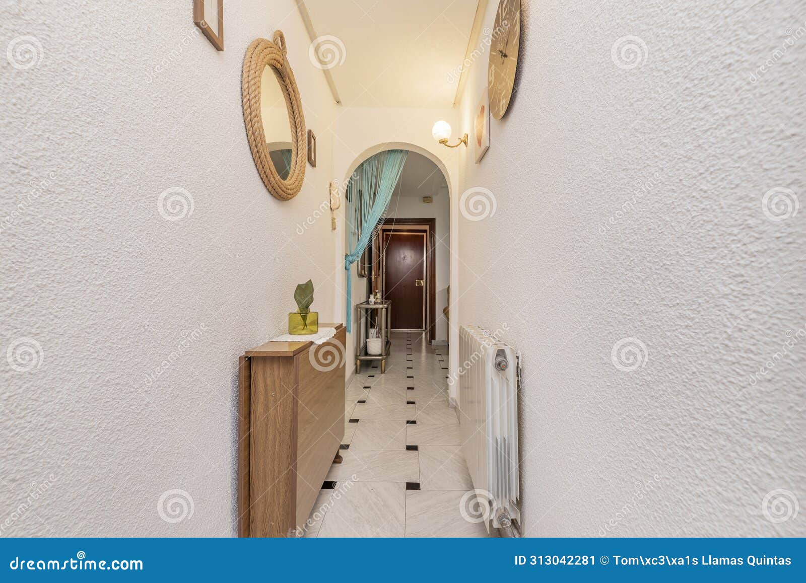 hallway of an apartment with black and white stoneware floors, white walls with gotelet paint, semicircular arch and decorative