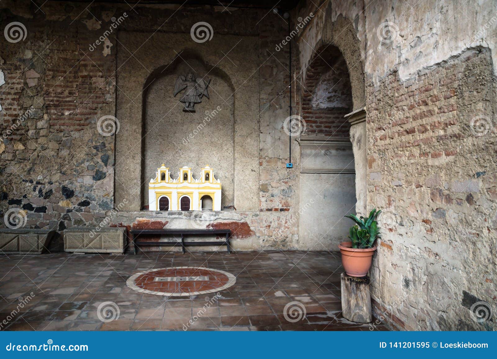 hallway of hermano pedro monestery with plant and arch, antigua, guatemala