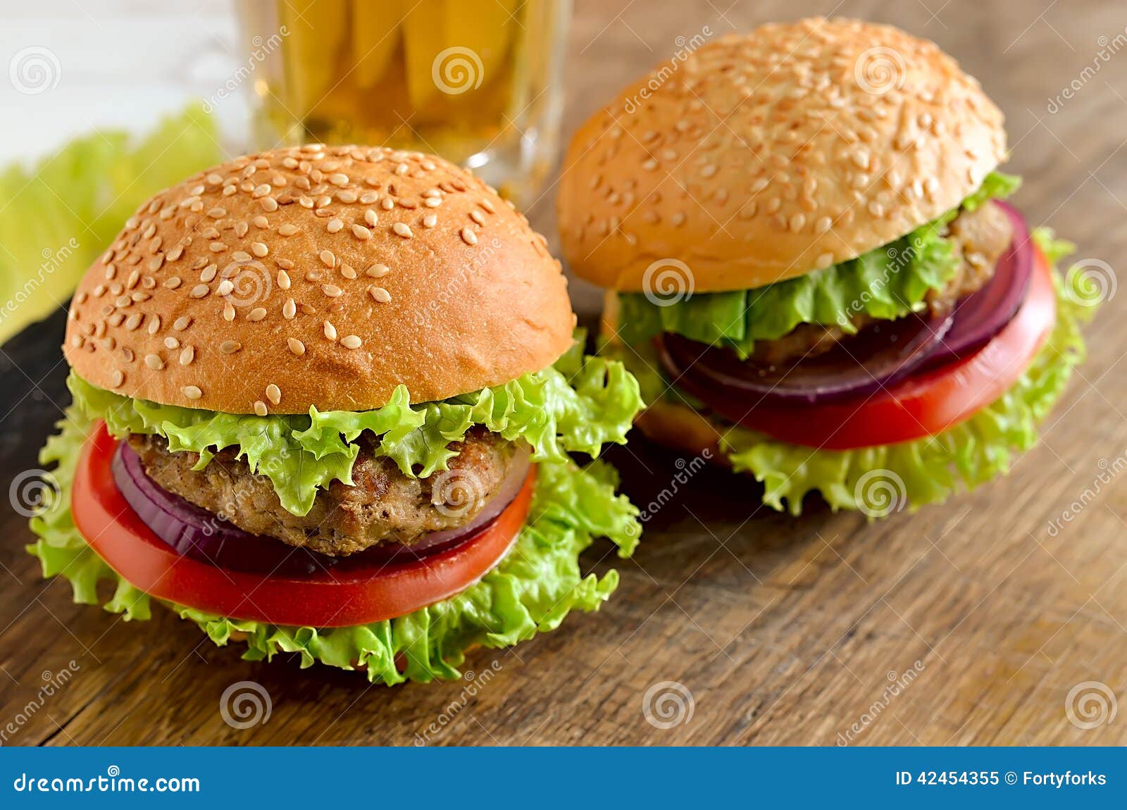 Hamburger casalingo classico con lattuga, le cipolle spagnole ed il pomodoro su un panino dei semi di sesamo Fine in su Fuoco di Sevective