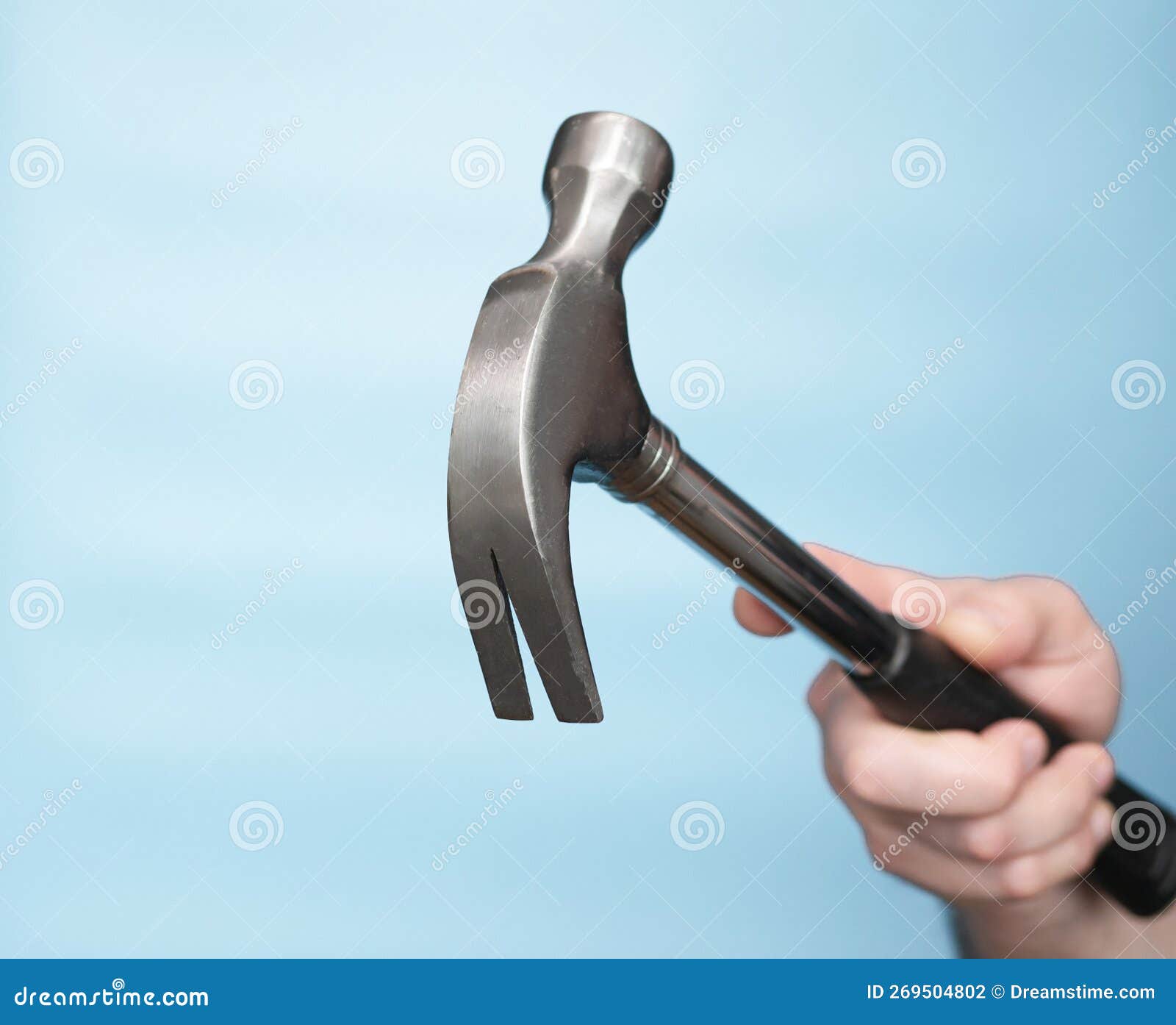 Hammer Construction Nail Puller in the Hand of a Man on a Blue Background. Imitation of