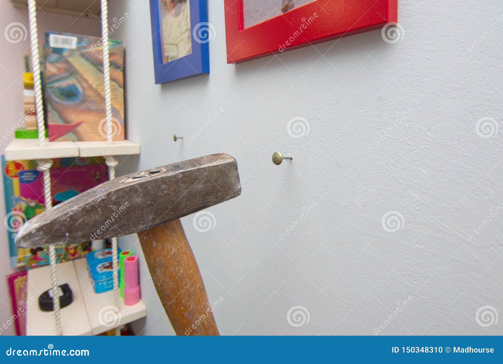 A Hammer Hammers a Nail into the Wall, Hanging Frames with Photos Stock