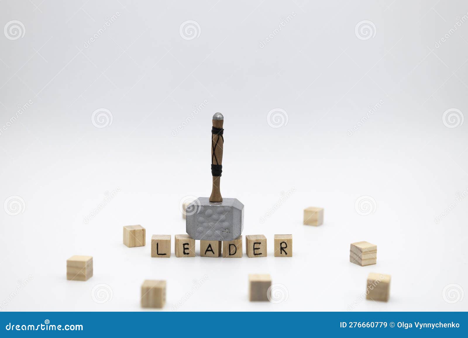 the hammer is standing on the wooden cubes with the word leader against white background