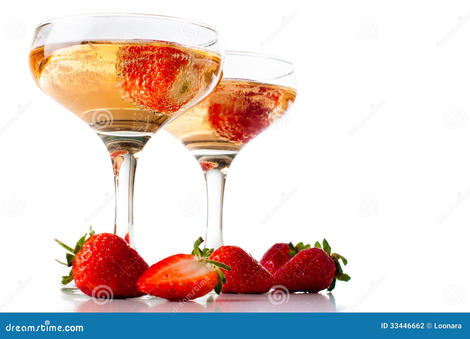 Hampagne con le fragole su un fondo bianco. Due vetri di champagne freddo con le fragole su un fondo bianco, isolati, primo piano