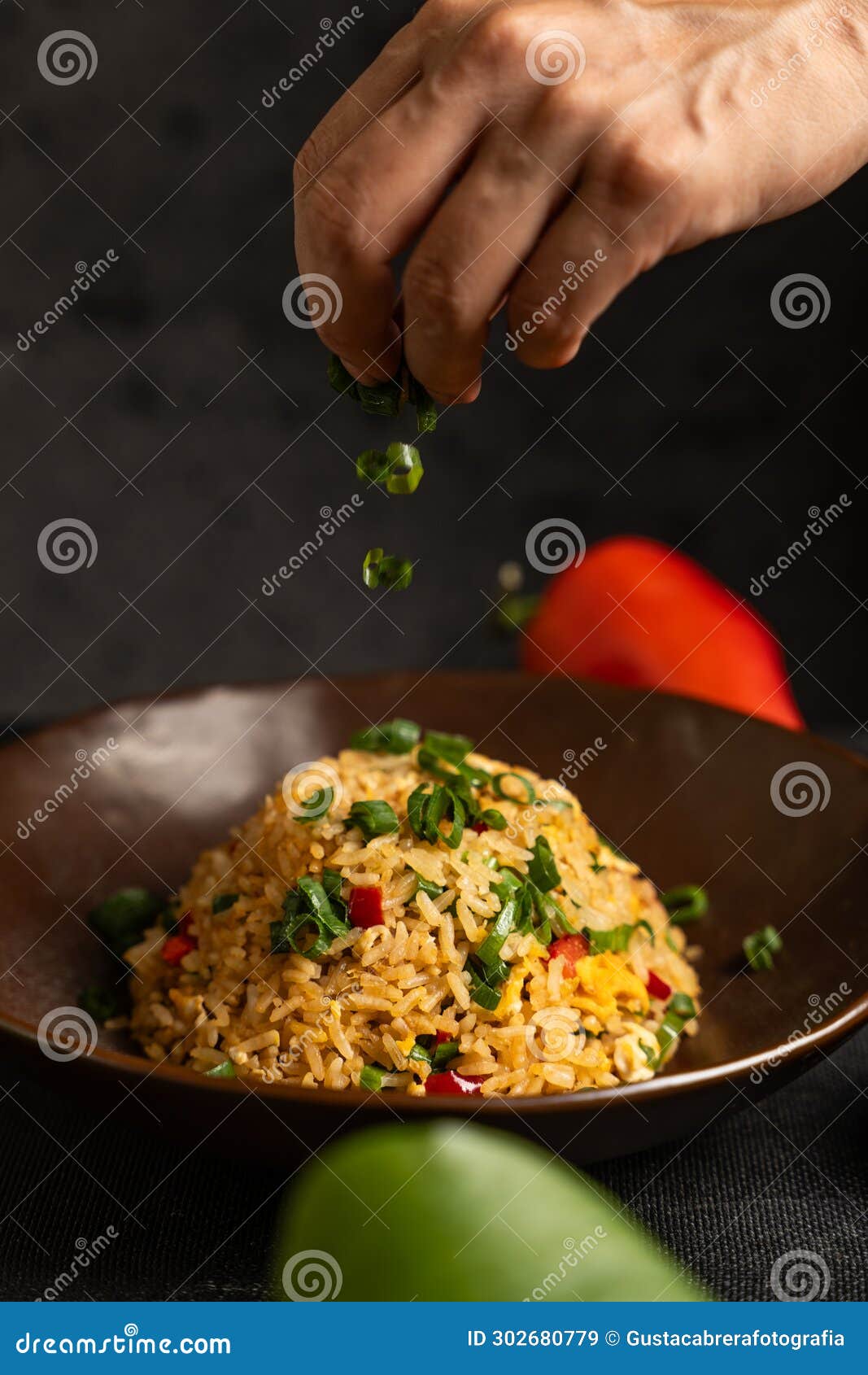 hand adding the last ingredients to the dish.