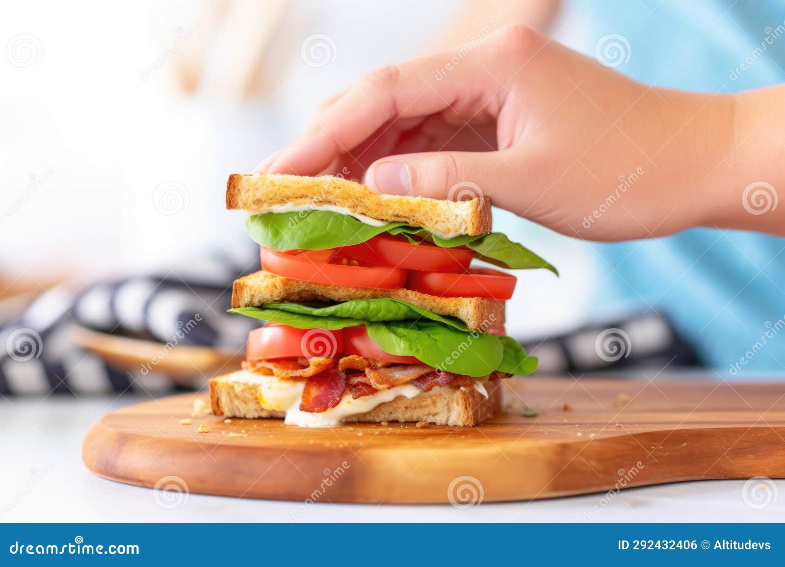 Hand Adjusting the Toasted Bread on Top of a Classic Blt Breakfast