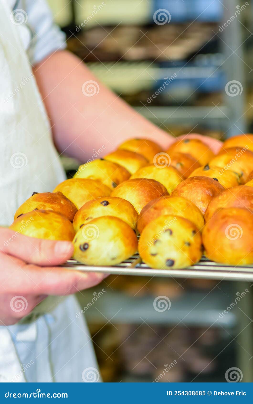 Hand of Baker or Apprentice Baker Taking Out the Milk Breads from the