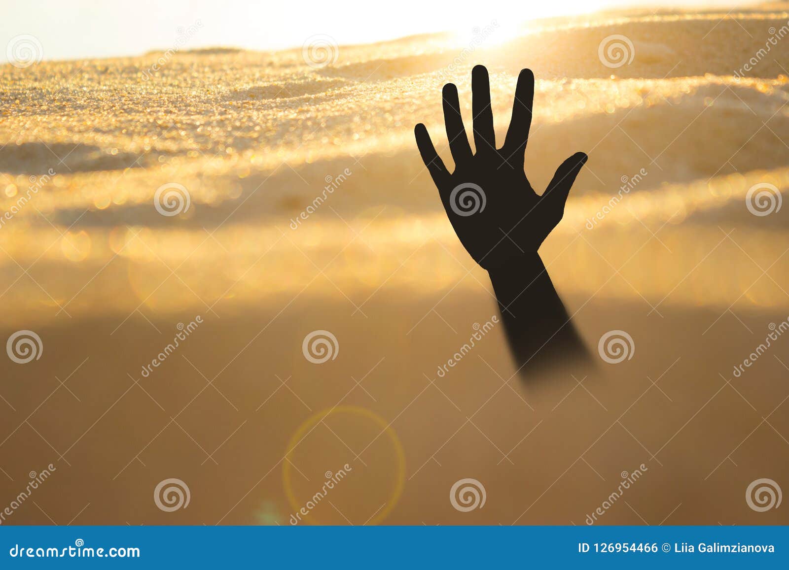 Hand On A Beach Sinking Or Drowning In Quicksand Stock Photo