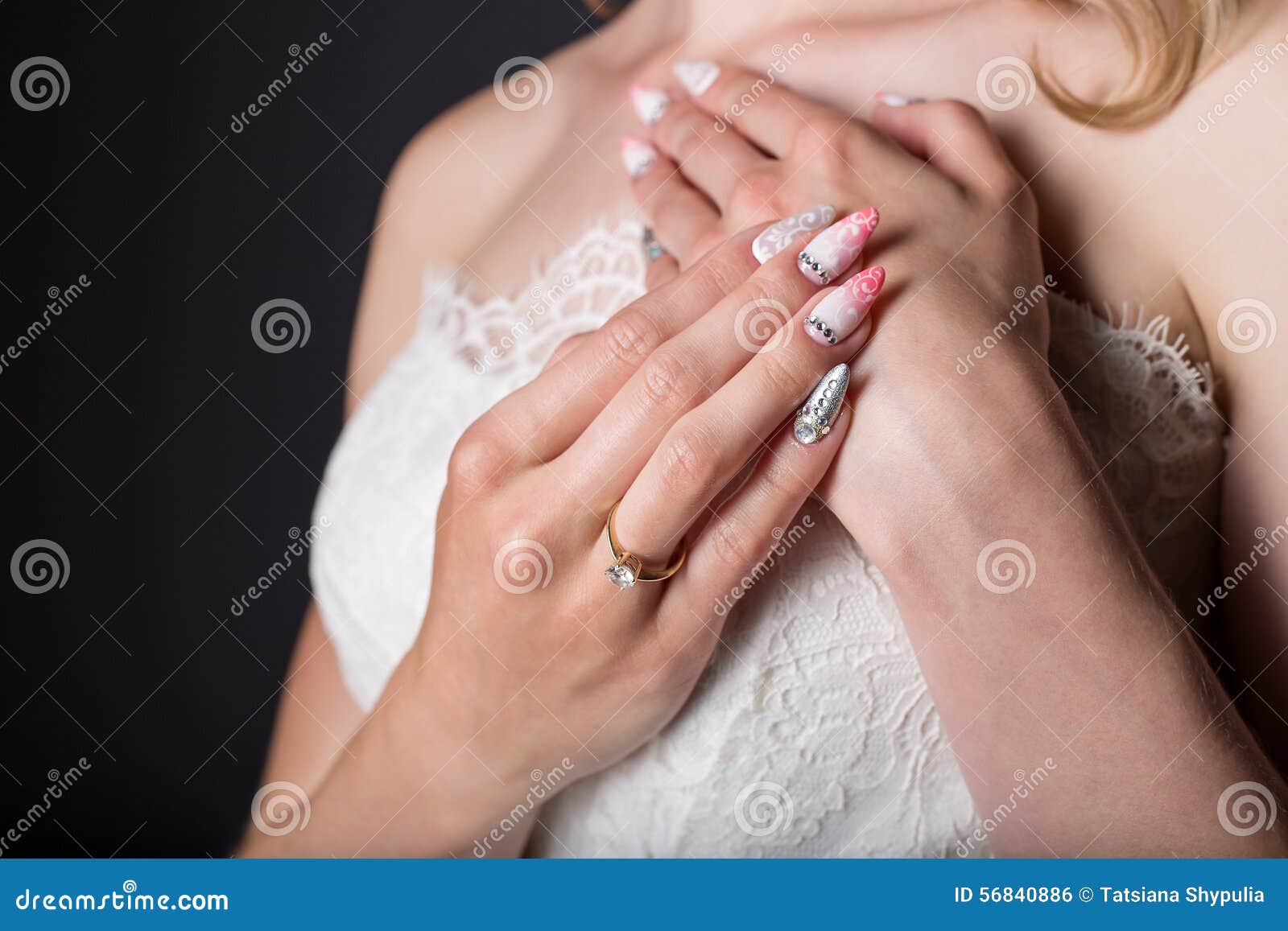 hand beautiful girl bride in white wedding dress with acrylic nails and delicate pattern and rhinestones