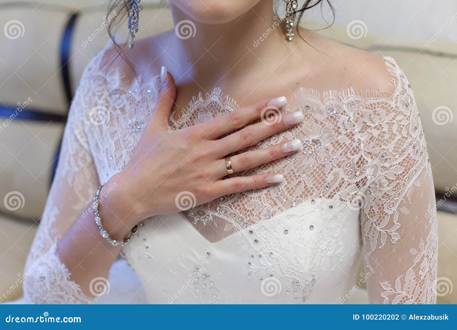 Bride Holds Her Hand with an Engagement Ring on Chest Stock Photo
