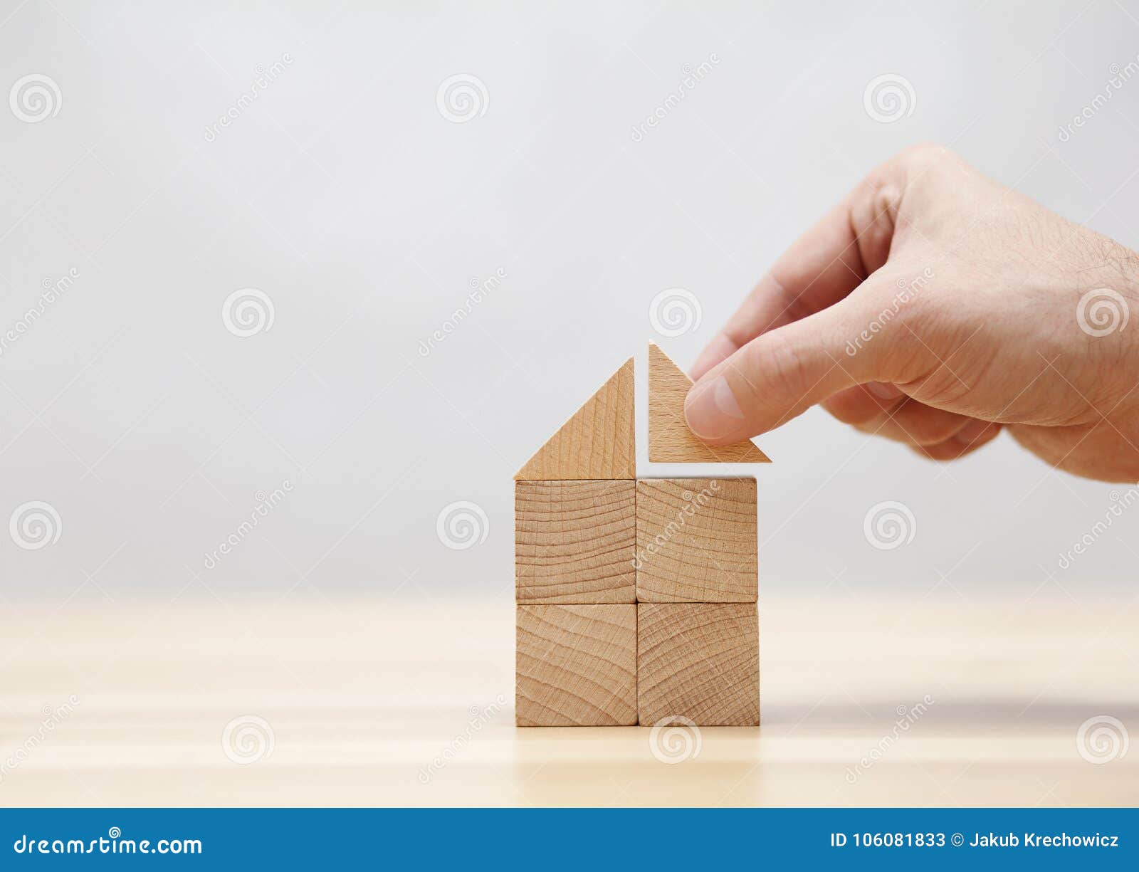 hand building house with wooden blocks