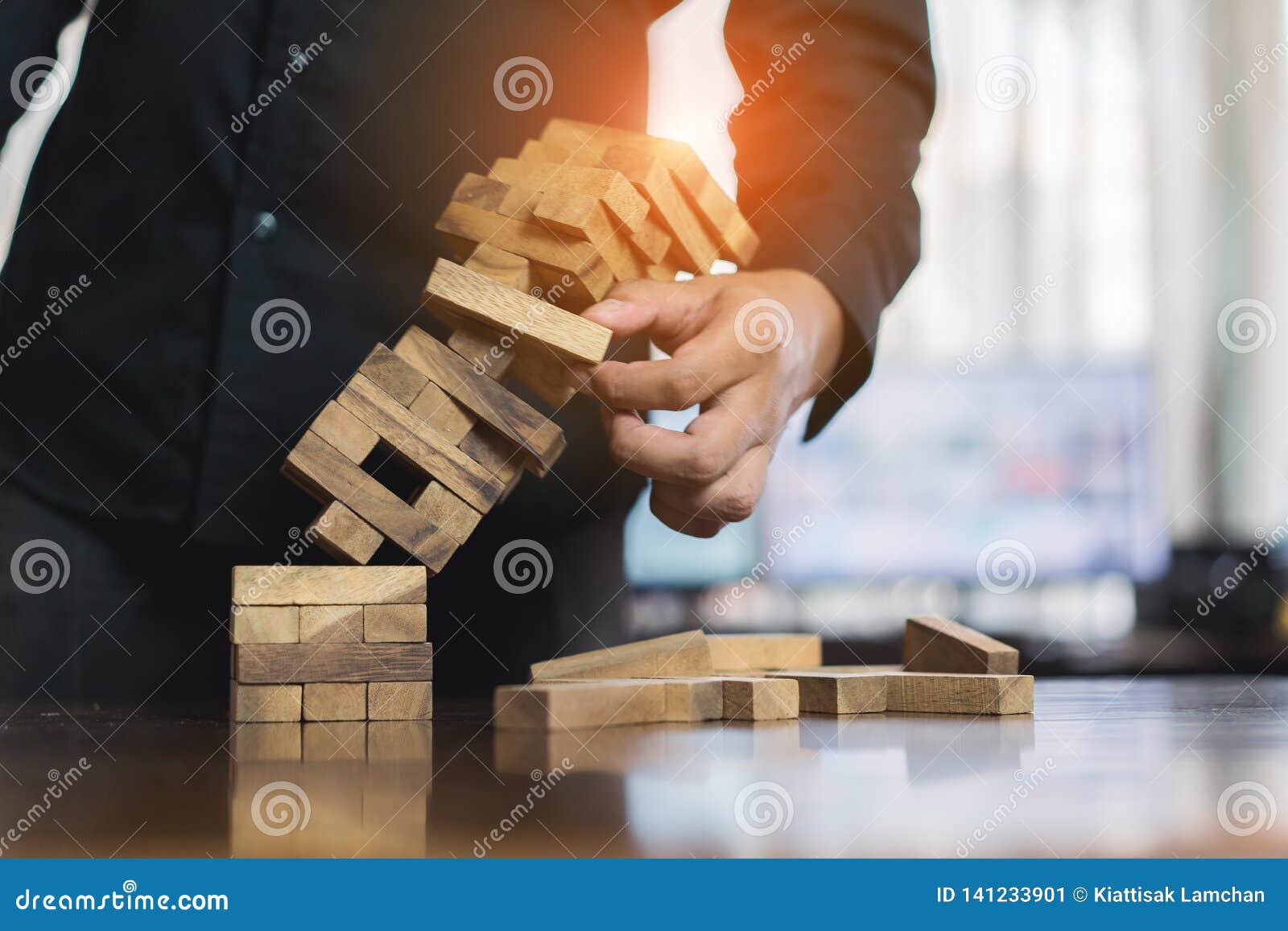 hand of businessman pulling wood block fail on building