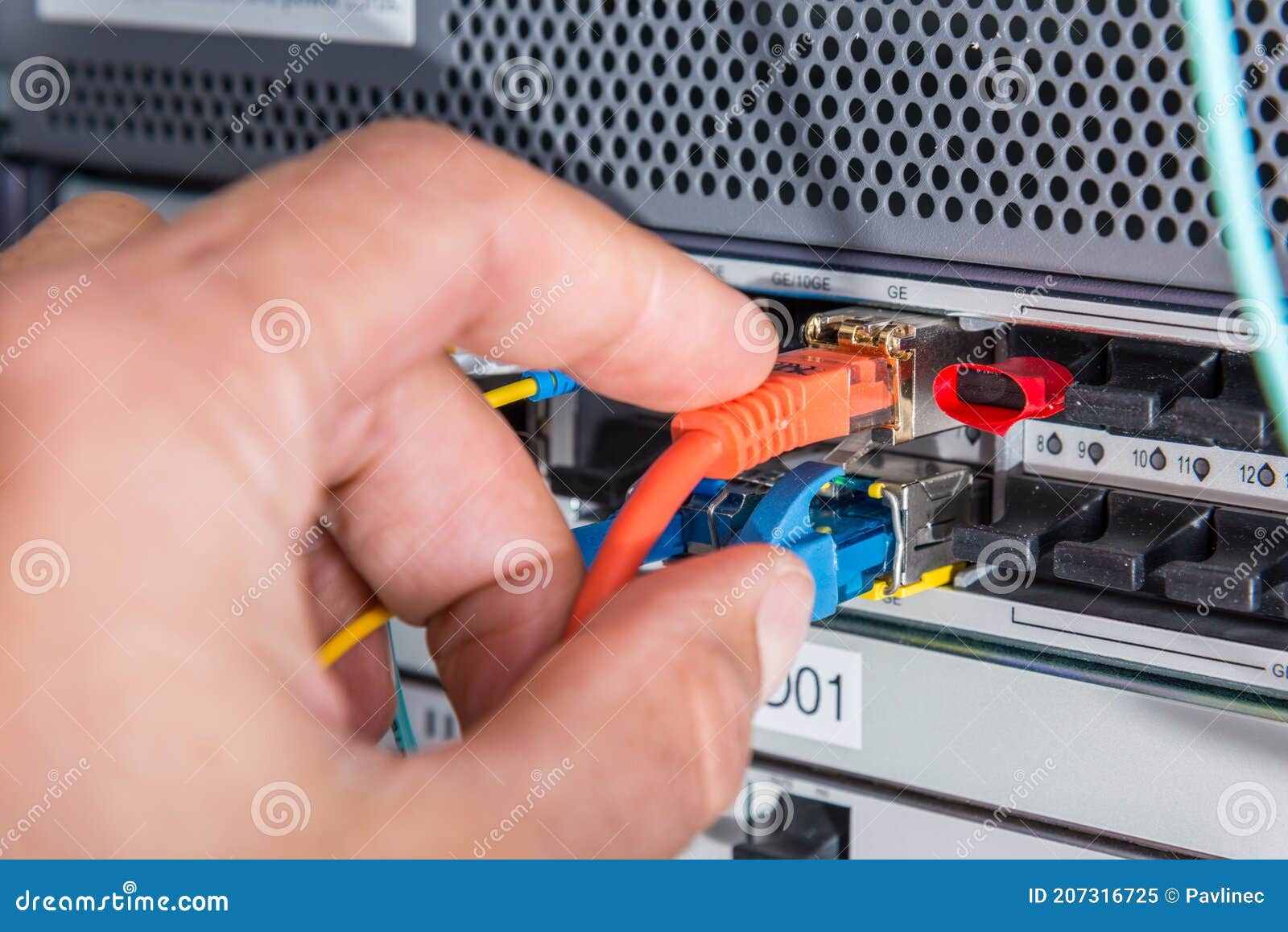 Hand of Computer Engineer Connecting Fiber Optic Cable in Server Stock