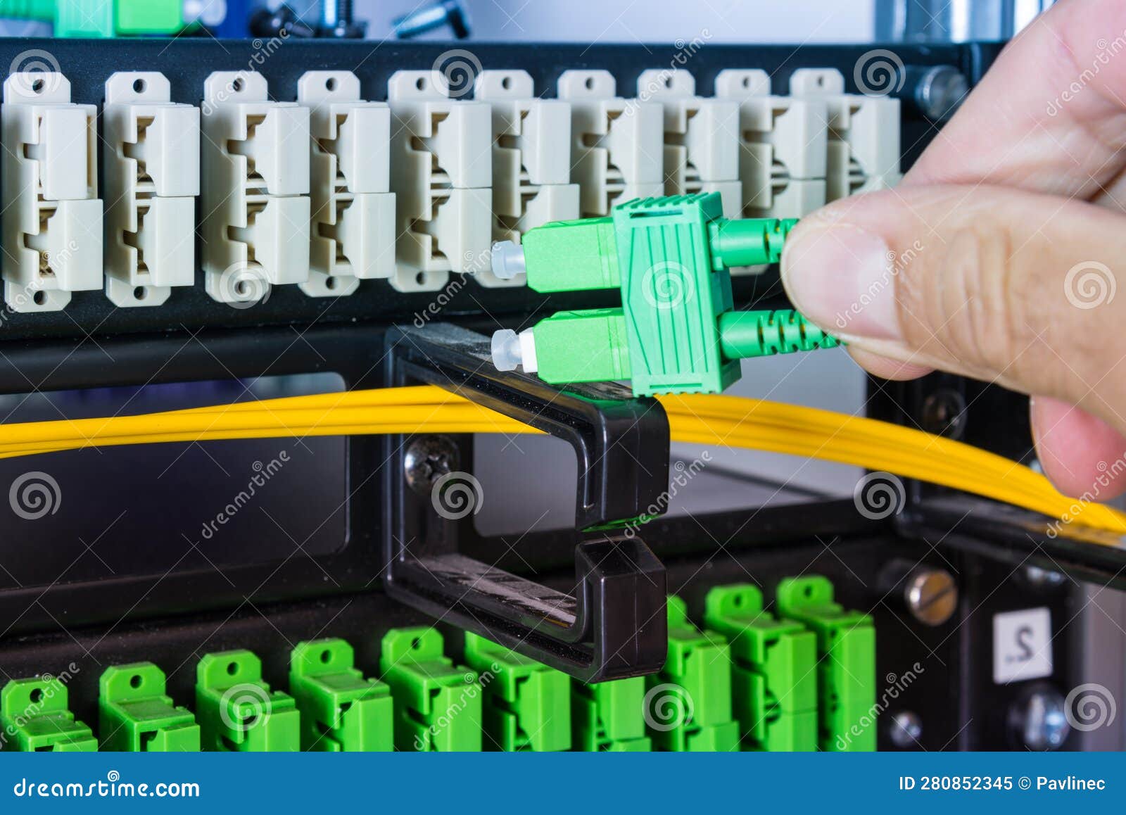 Hand of Computer Engineer Connecting Fiber Optic Cable in Server Stock
