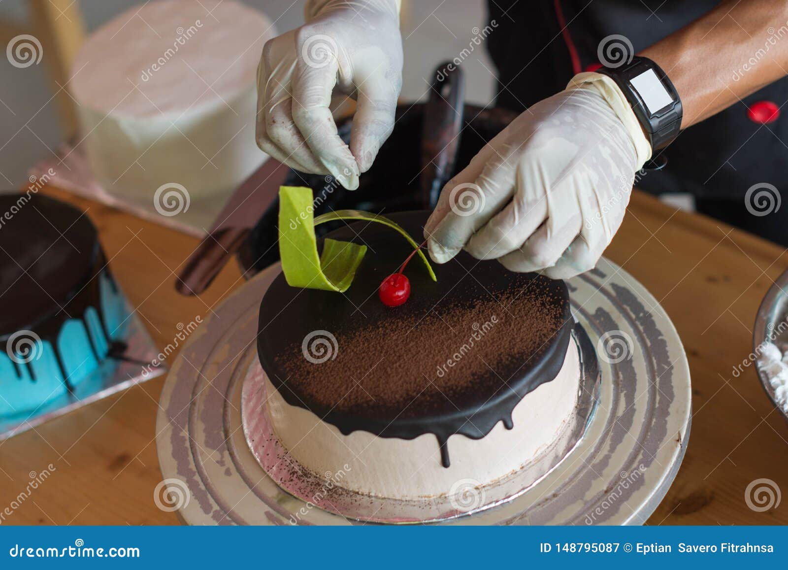 Hand of Pastry Chef Decorating Chocolate Cake with Cherry and Green Candy Stock Image Image of