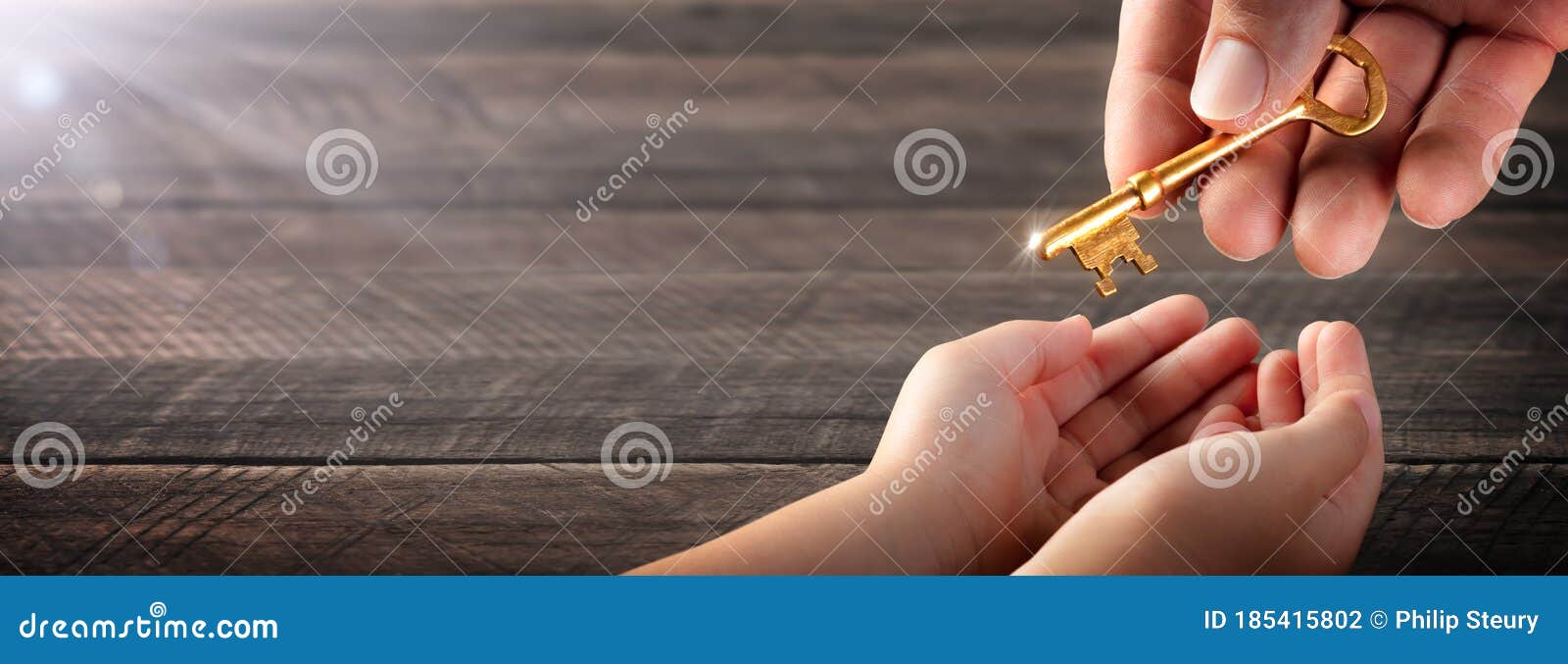 hand of father giving old golden key to child