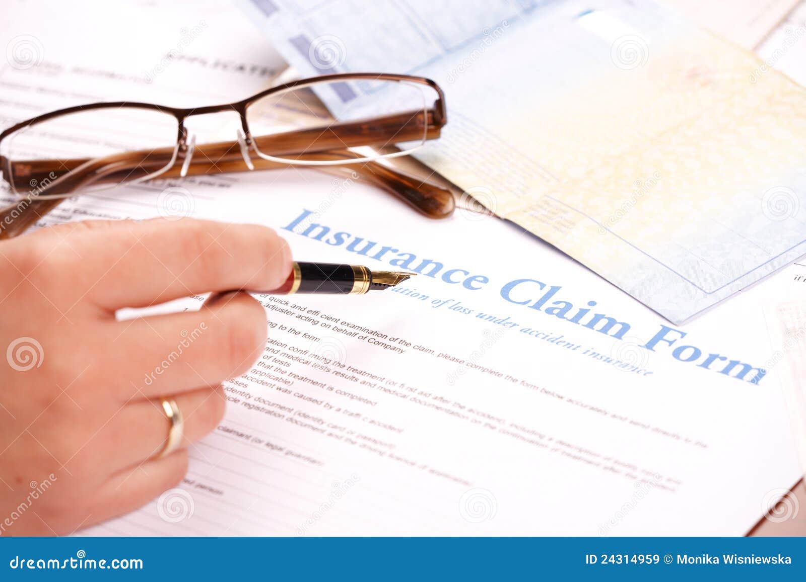 hand filling in insurance claim form