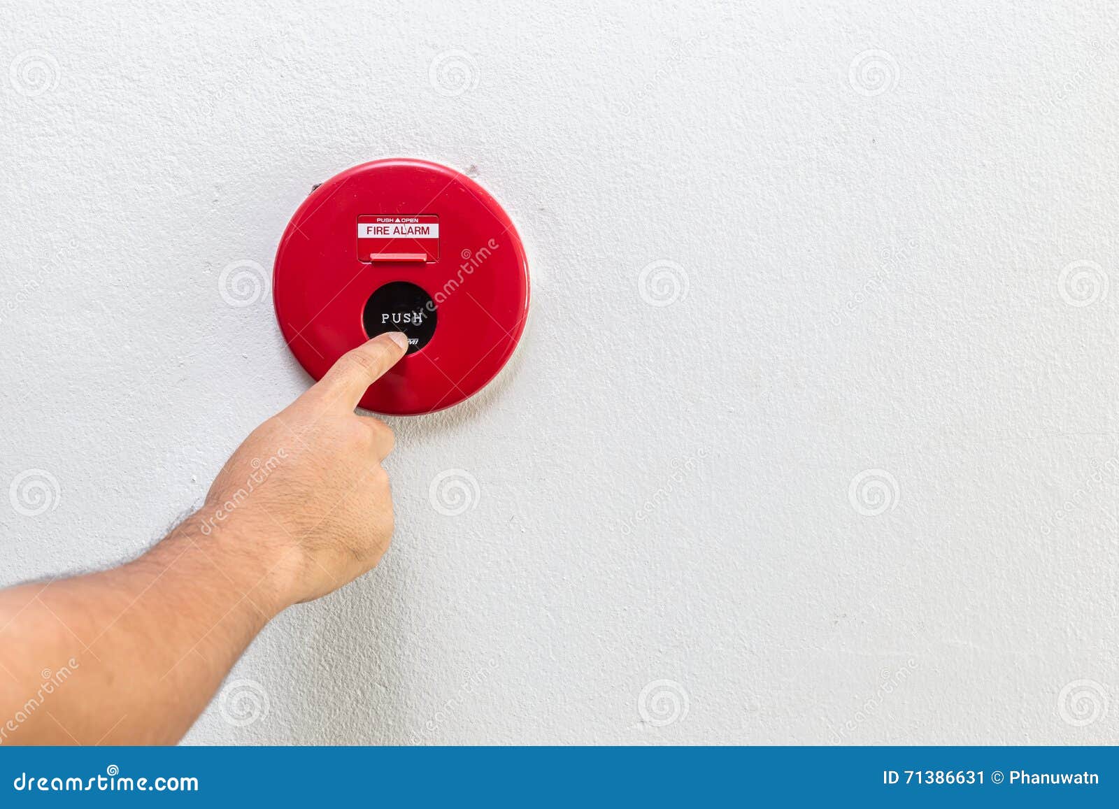 Hand with Finger Pressing Red Fire Alarm on the Wall Stock Image