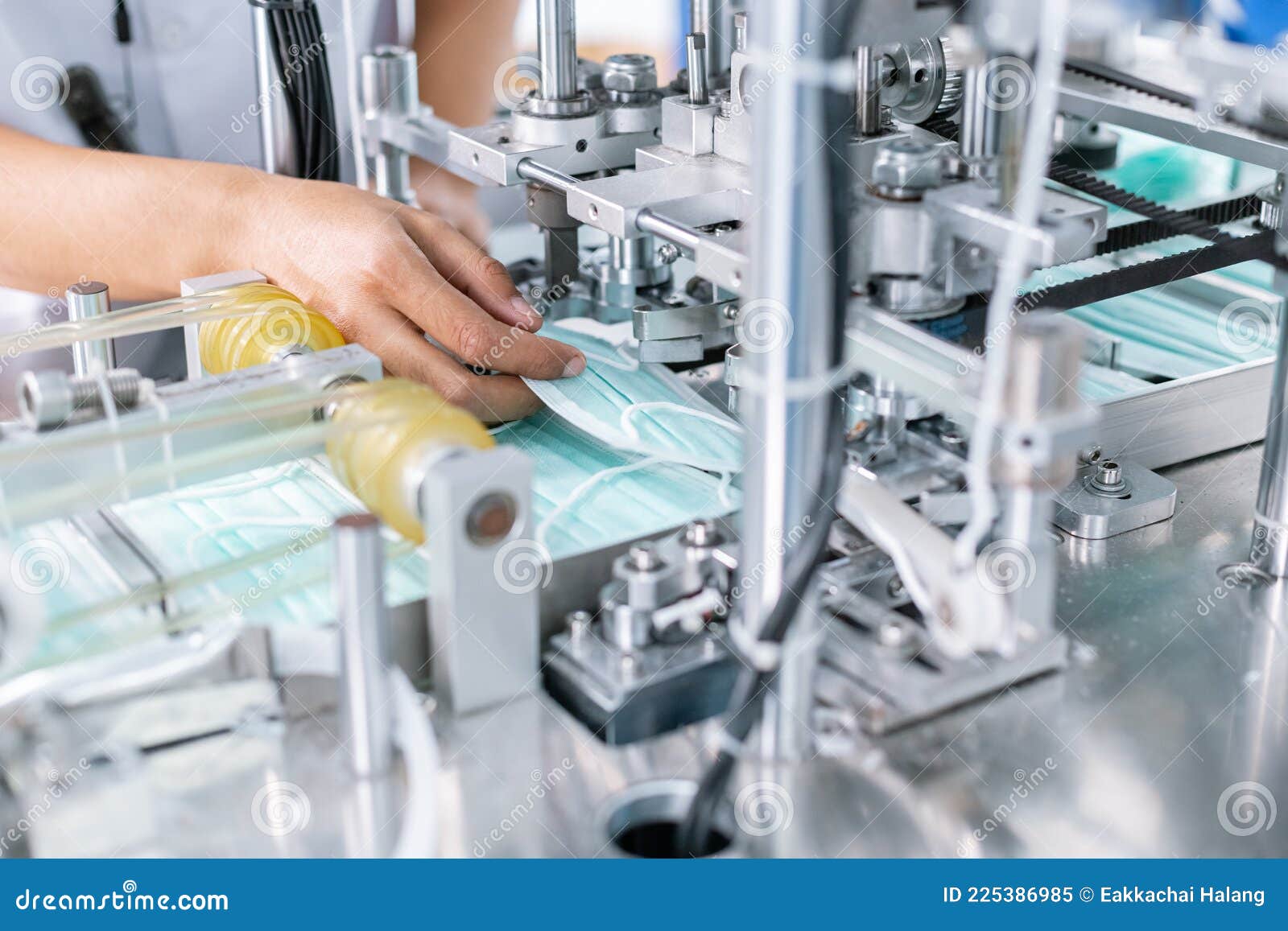 hand of functionary worker take hygienic face mask in machine production, mask manufacturing factory