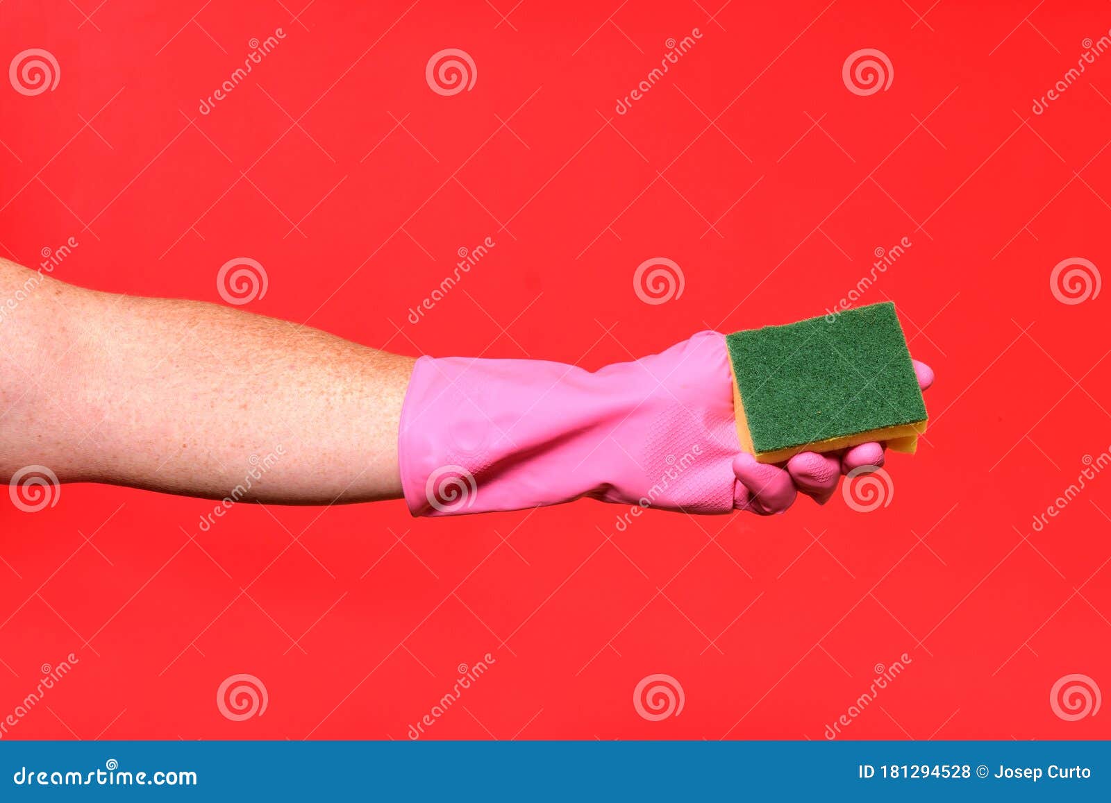 hand with glove hoding scourer on red background