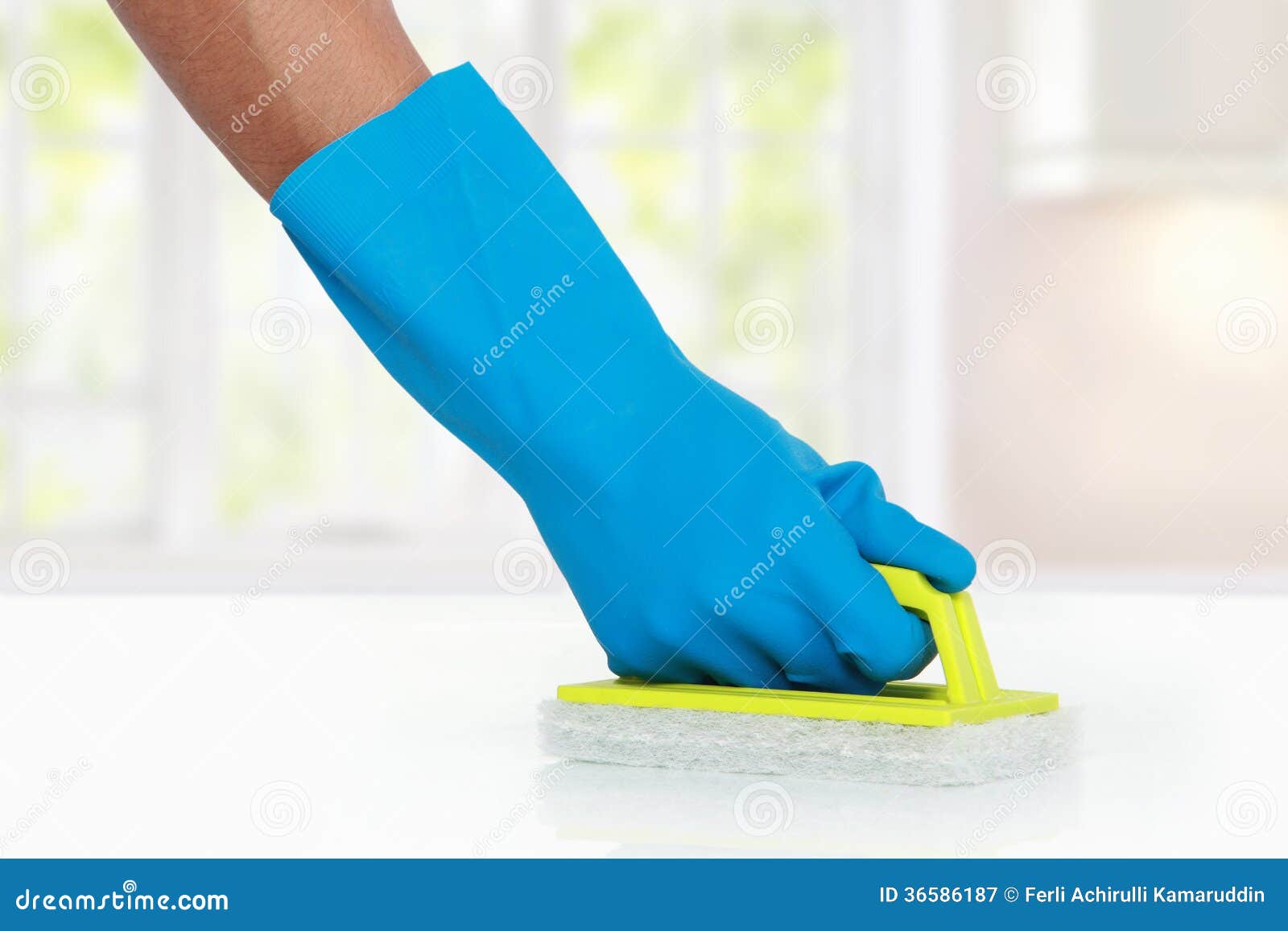 Hand with Glove Using Green Cleaning Sponge To Clean Up Stock Image