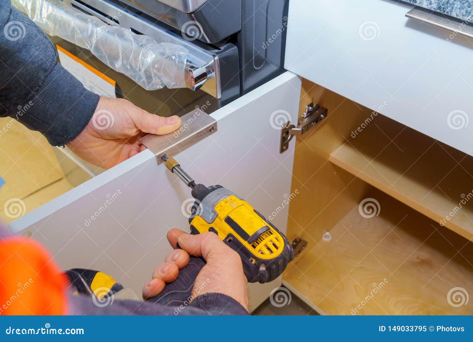 Hand On Handle Installation Door In Kitchen Cabinet Stock Image