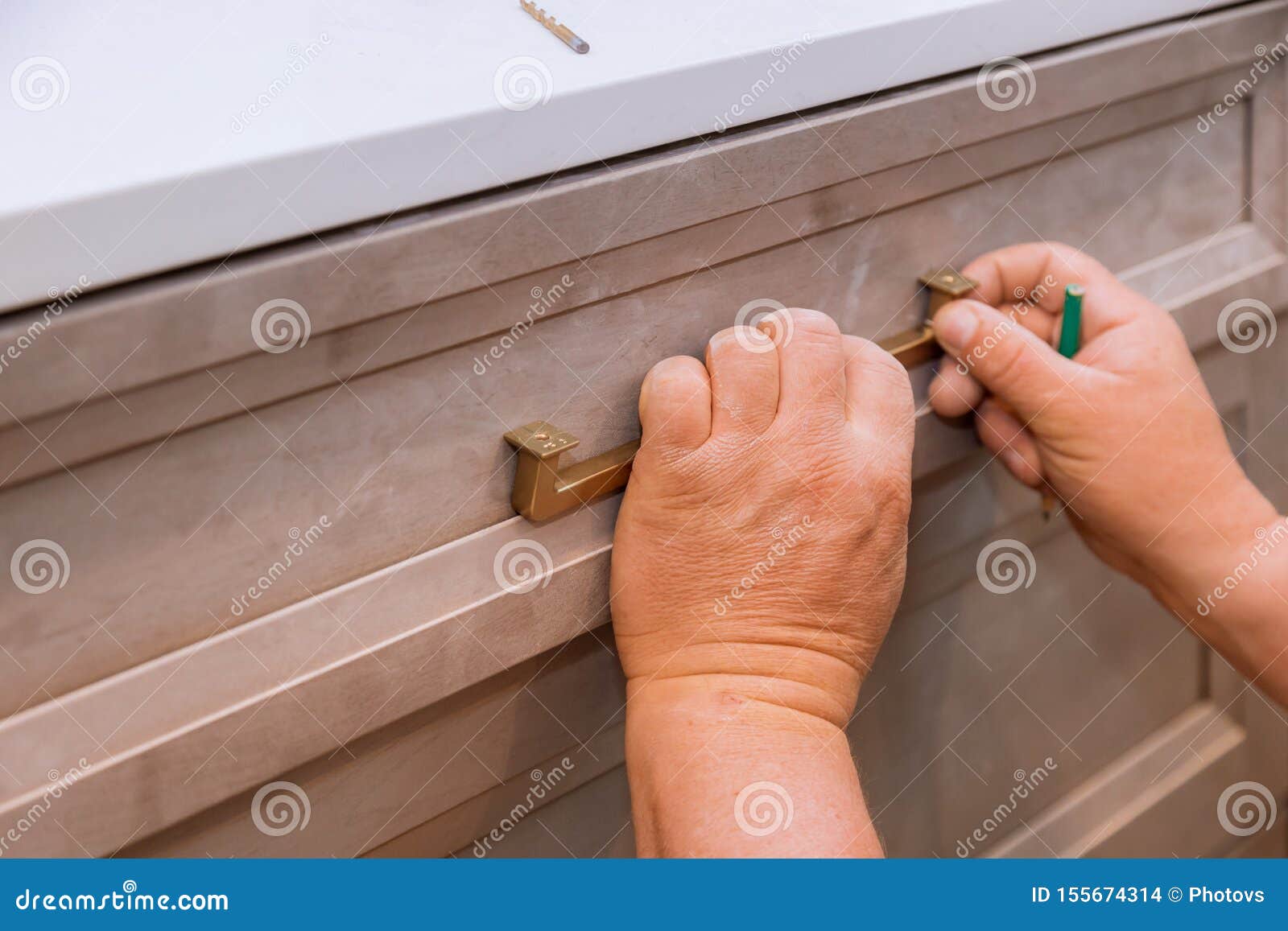 Hand on Handle Installation Drawers in Kitchen Stock Photo
