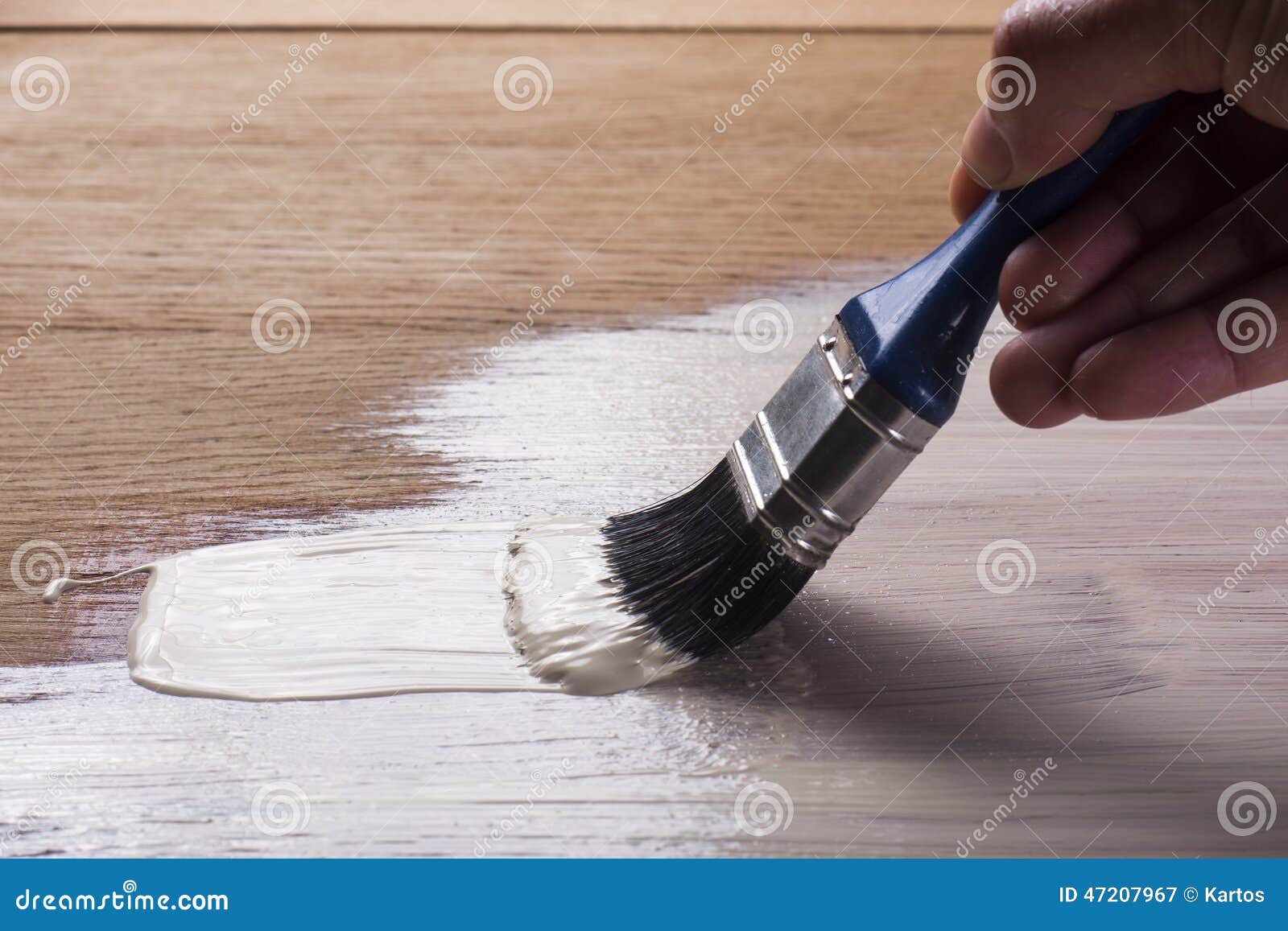 hand holding a brush applying varnish paint