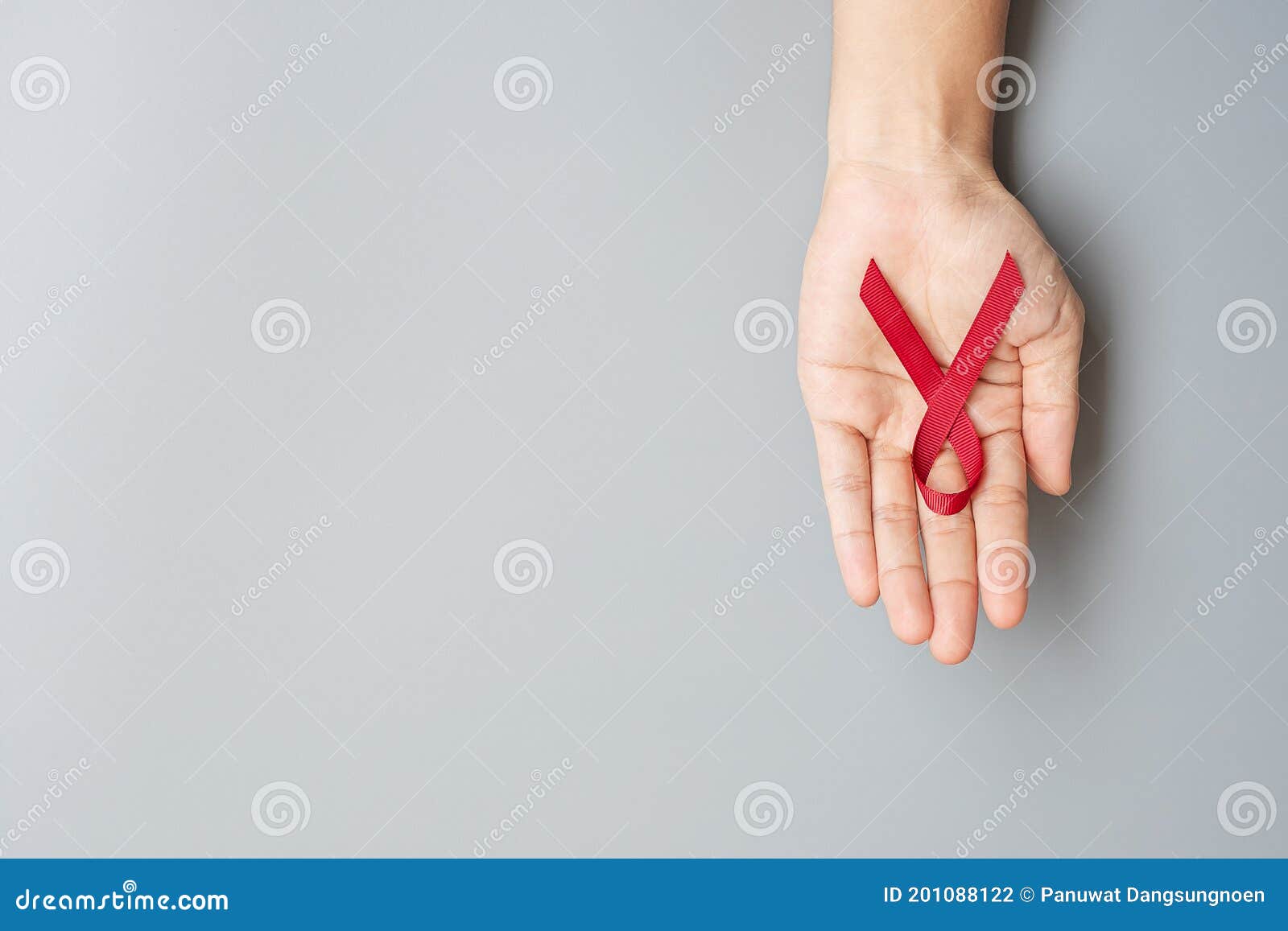 Hand Holding Burgundy Red Ribbon For Supporting People Living And