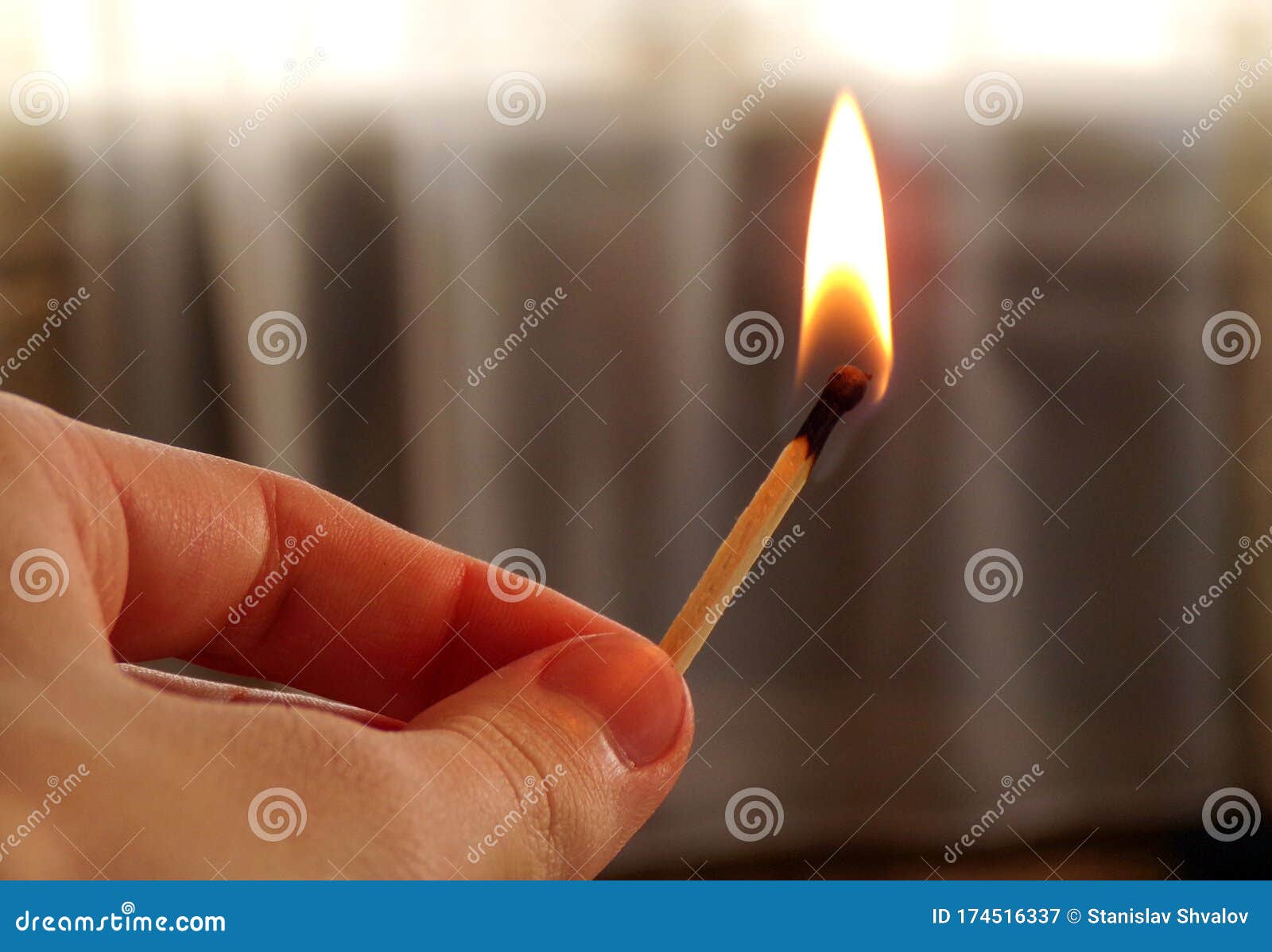 hand holding a burning match. match with fire and flame on a dark background. the concept of arson and fire. a burning match in hi