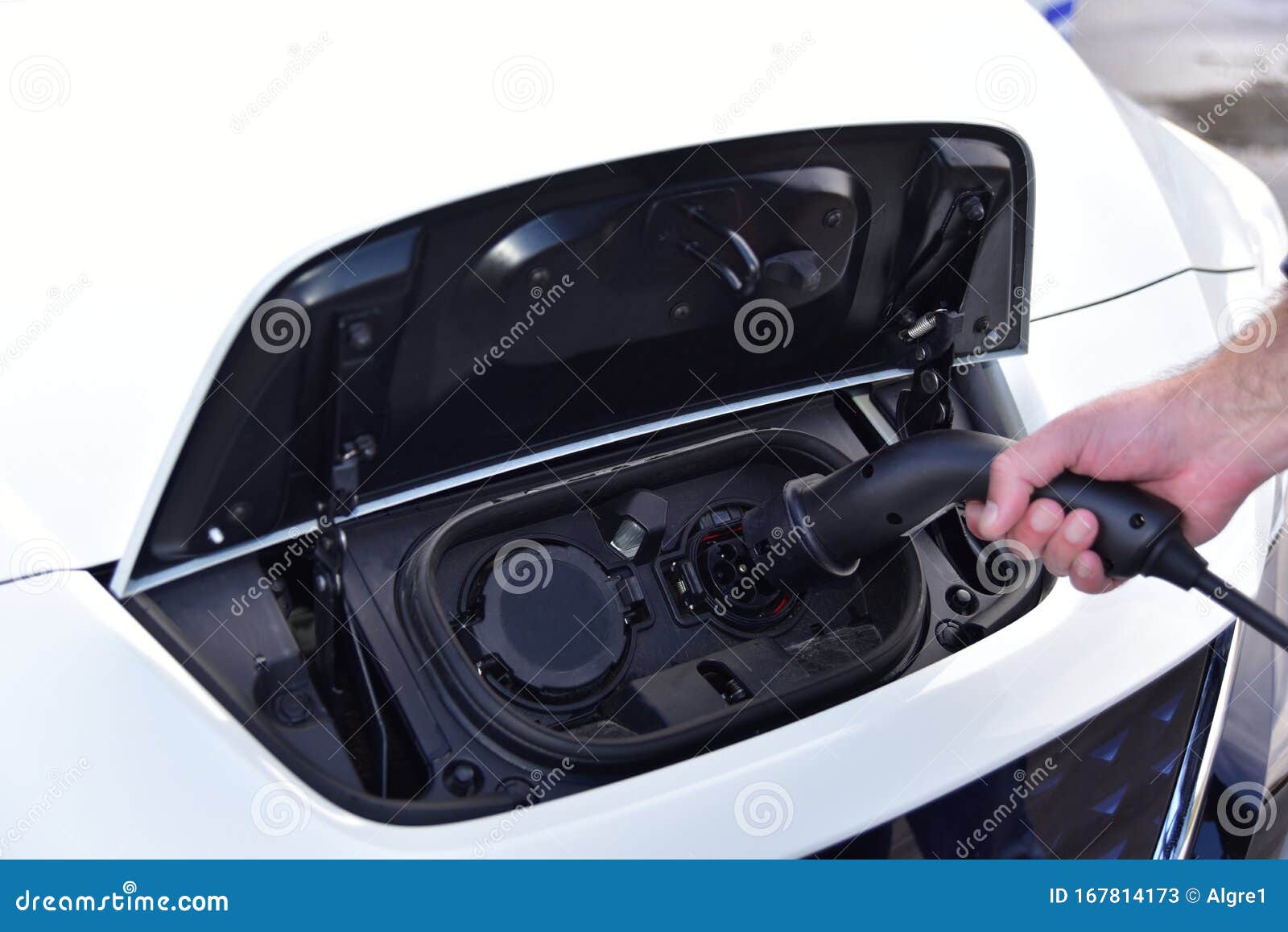 Hand Holding Electric Plug for Charging Electric Car Stock Image
