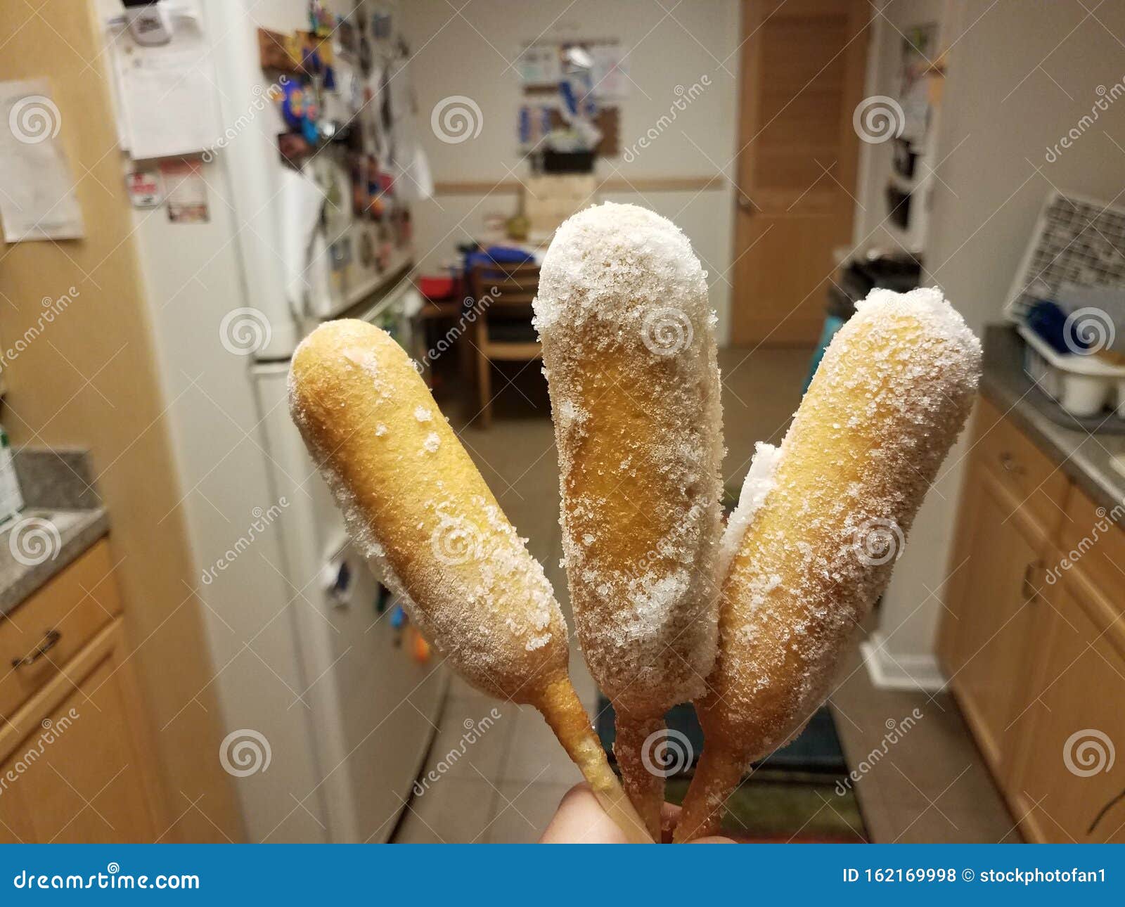 Hand Holding Frozen Corn Dogs in Kitchen Stock Photo Image of